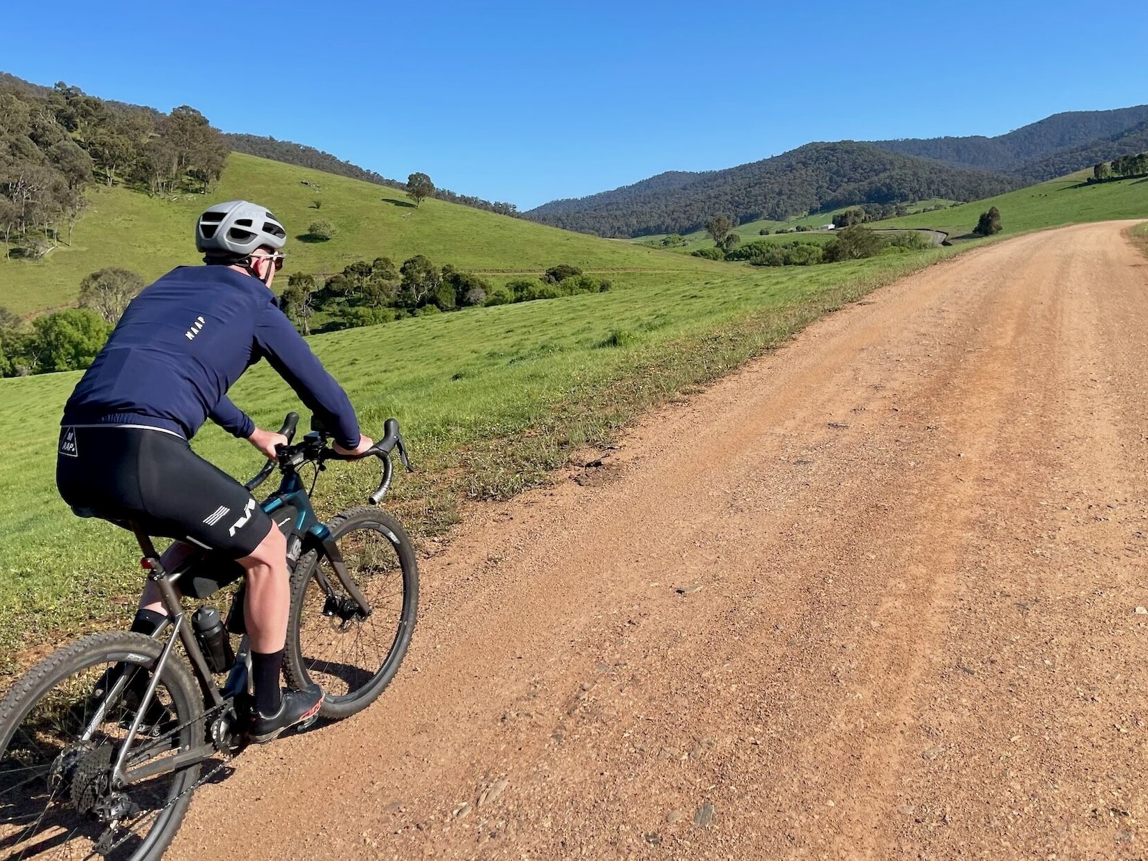 Cyclist riding on smooth gravel roads through farmland 