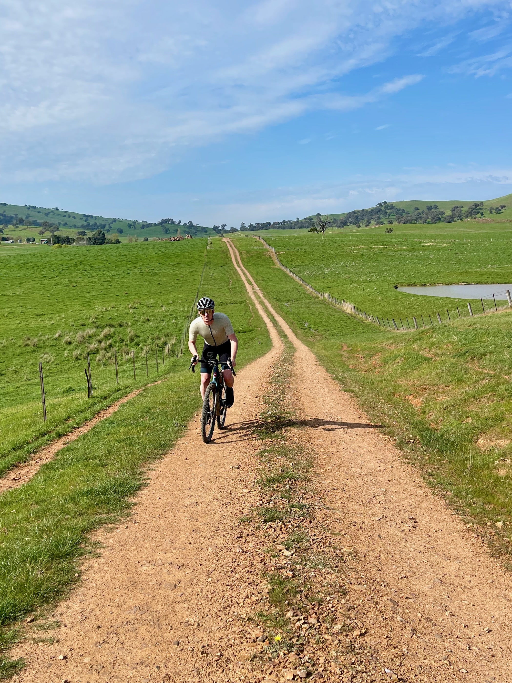 Cyclist riding ongravel roads in open farmland