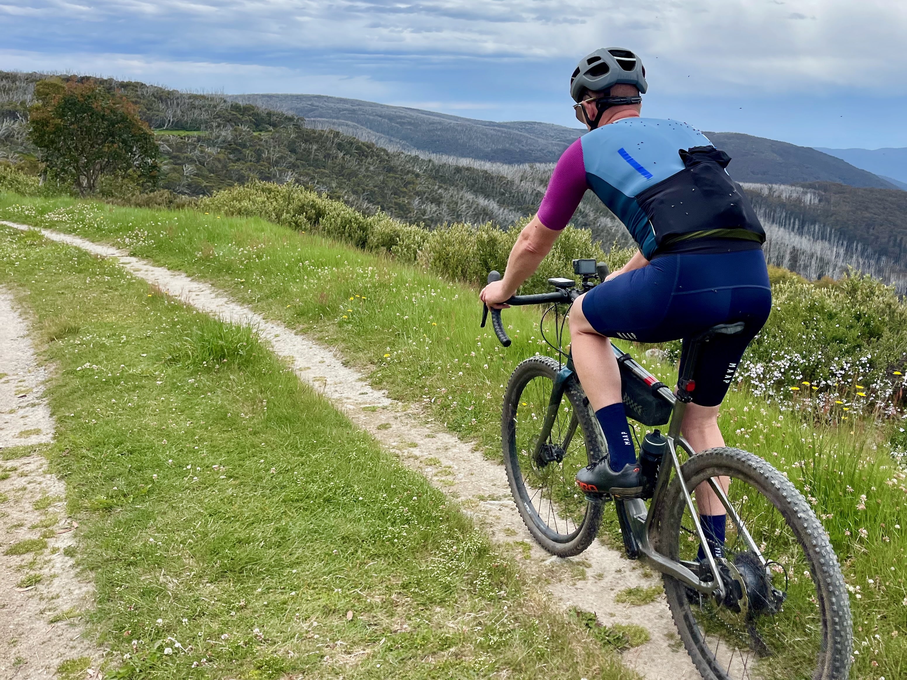 A cyclist riding on a gravel double track with views towards Glen Valley