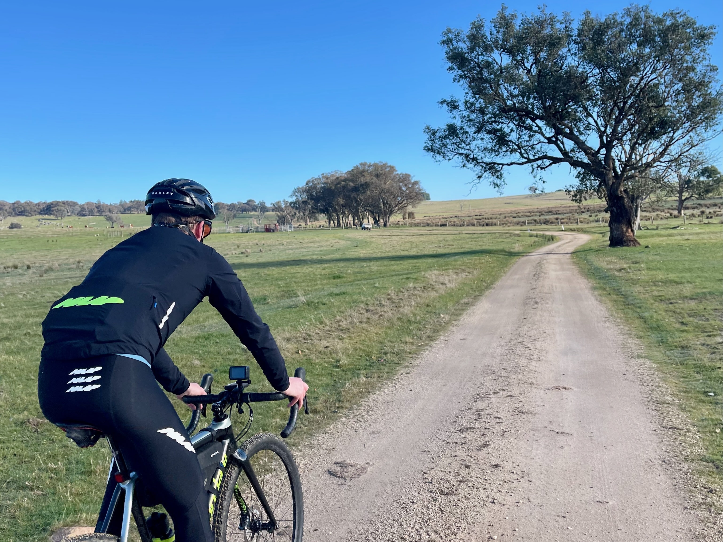 Gravel cyclist riding through the three gates surrounded by open farmland