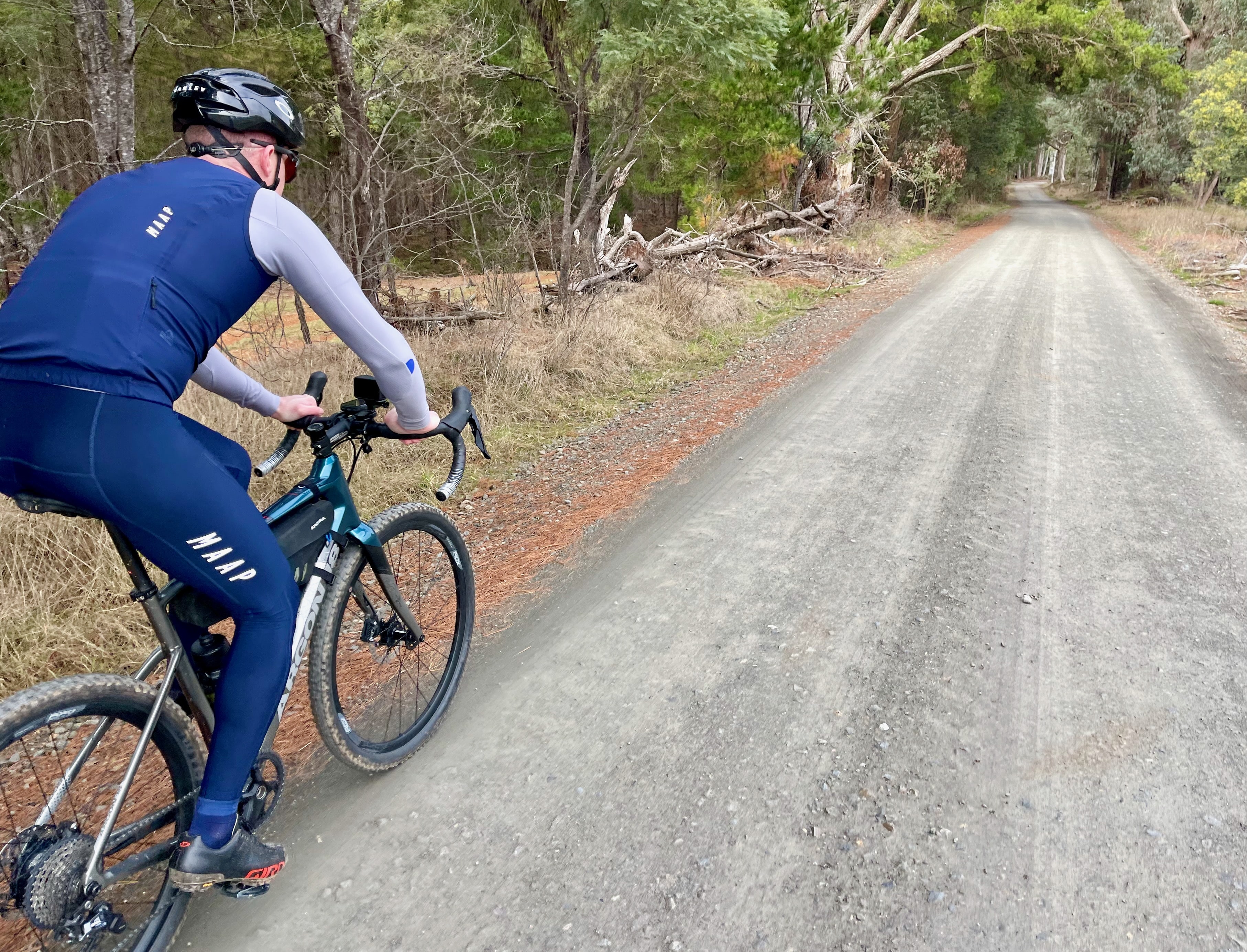 A cyclist riding on a smooth gravel road surrounded by native bushland