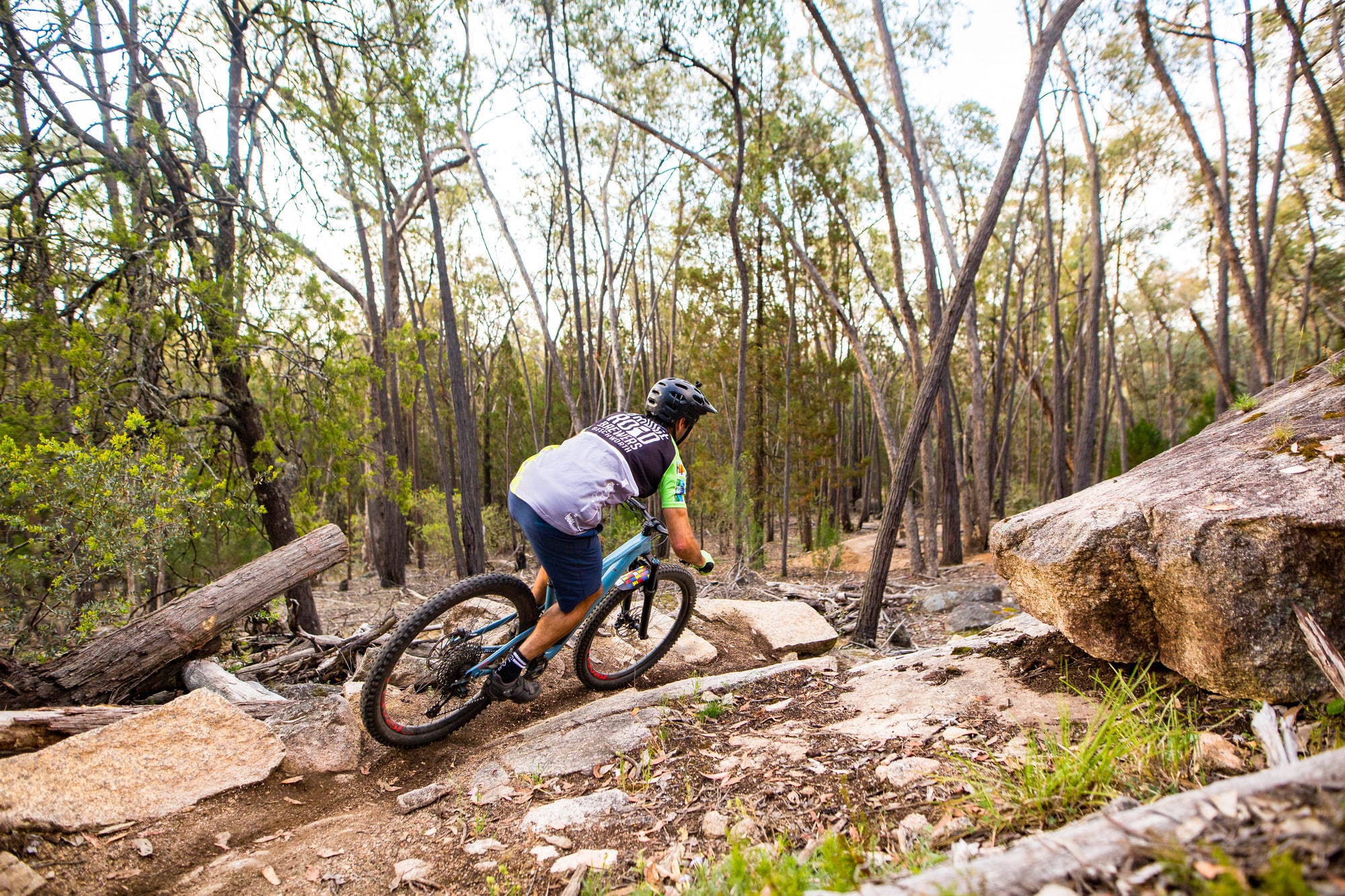 Cyclist riding Beechworth Mountain Bike Park's granite trails and technical features