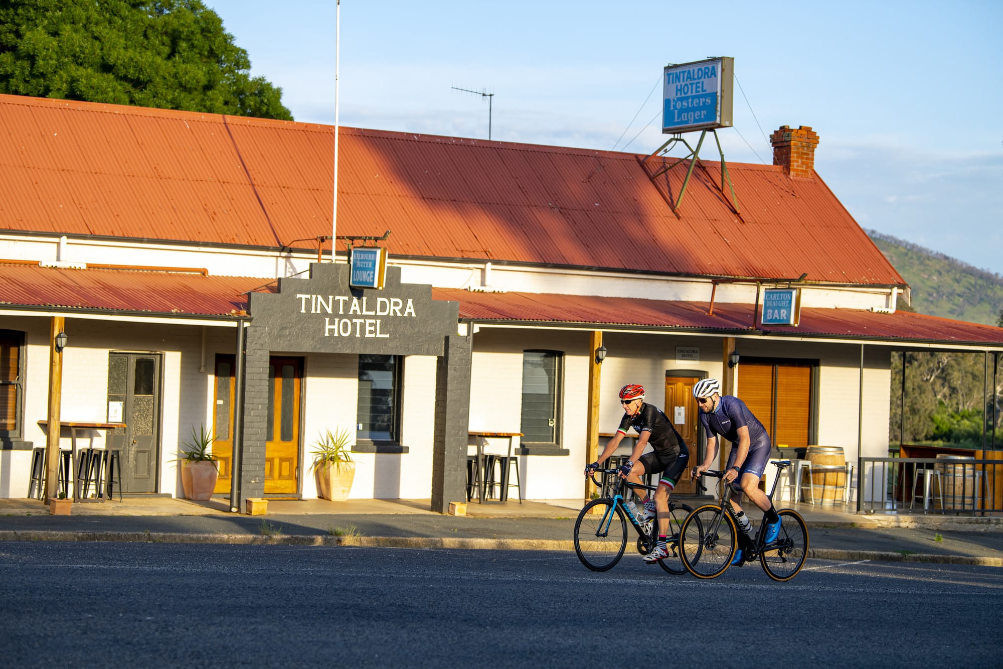 Road cyclists riding past Tintaldra Hotel