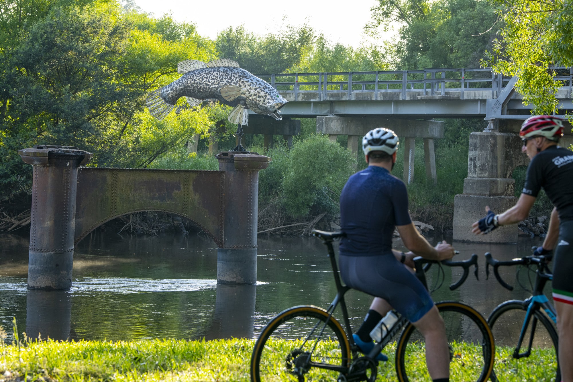 Two cyclists relaxing next to the Murray River at Tintaldra Bridge on the Border Loop