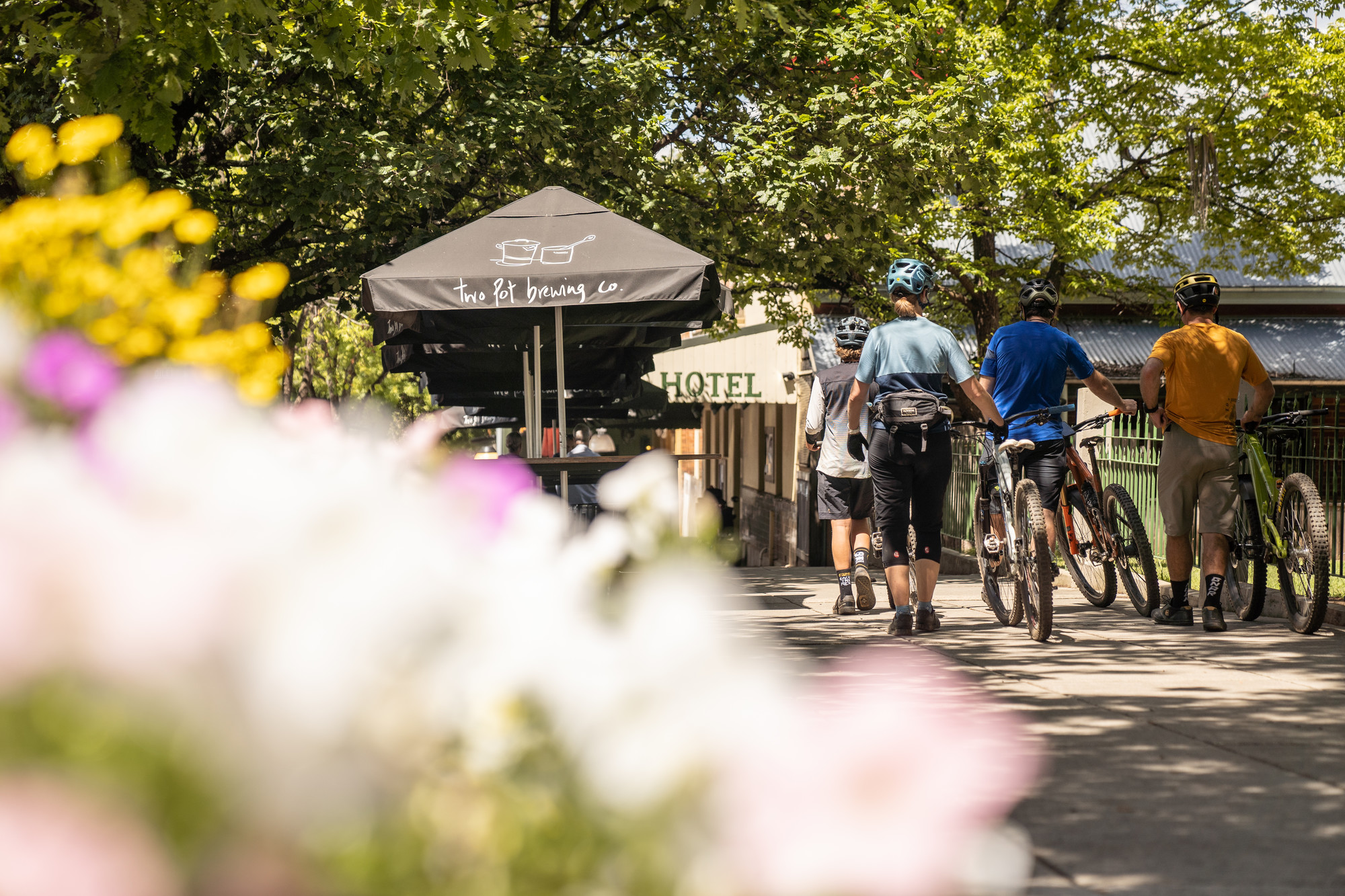 Group of cyclists rolling their bikes through Yackandandah township