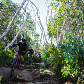 Cyclists riding over technical rock features on Cascades Trail