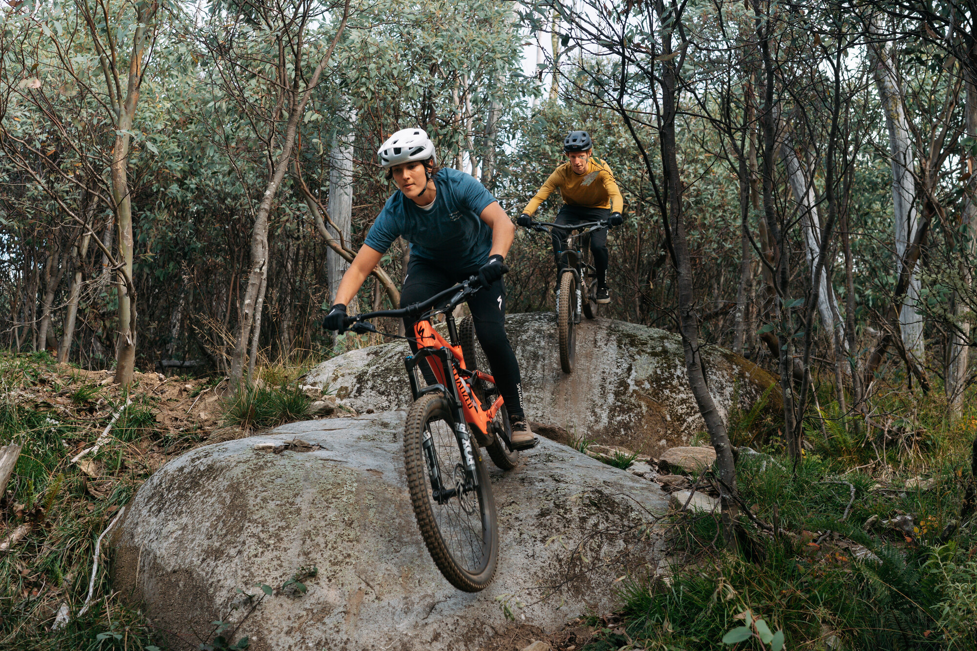 Two cyclists riding over rock features at Falls Creek Mountain Bike Park