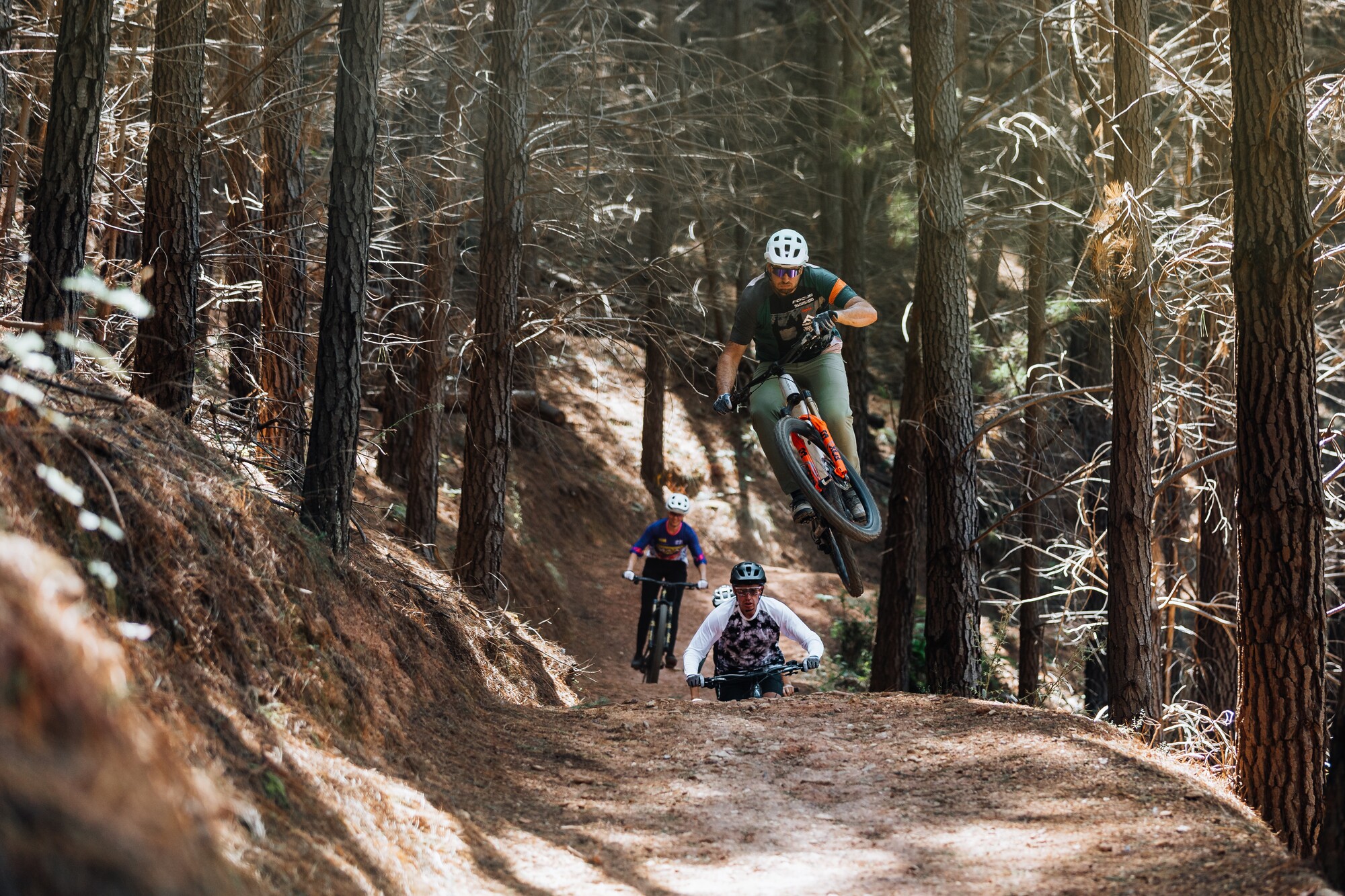 A group of riders pedalling through the pines at Mystic Bike Park