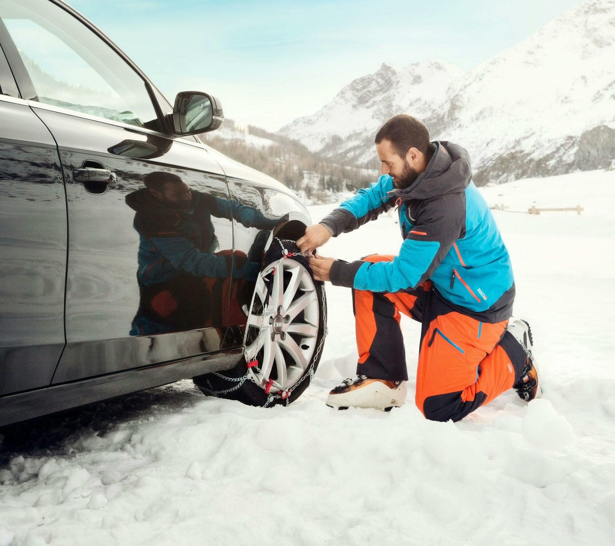 Man fitting chains in the snow