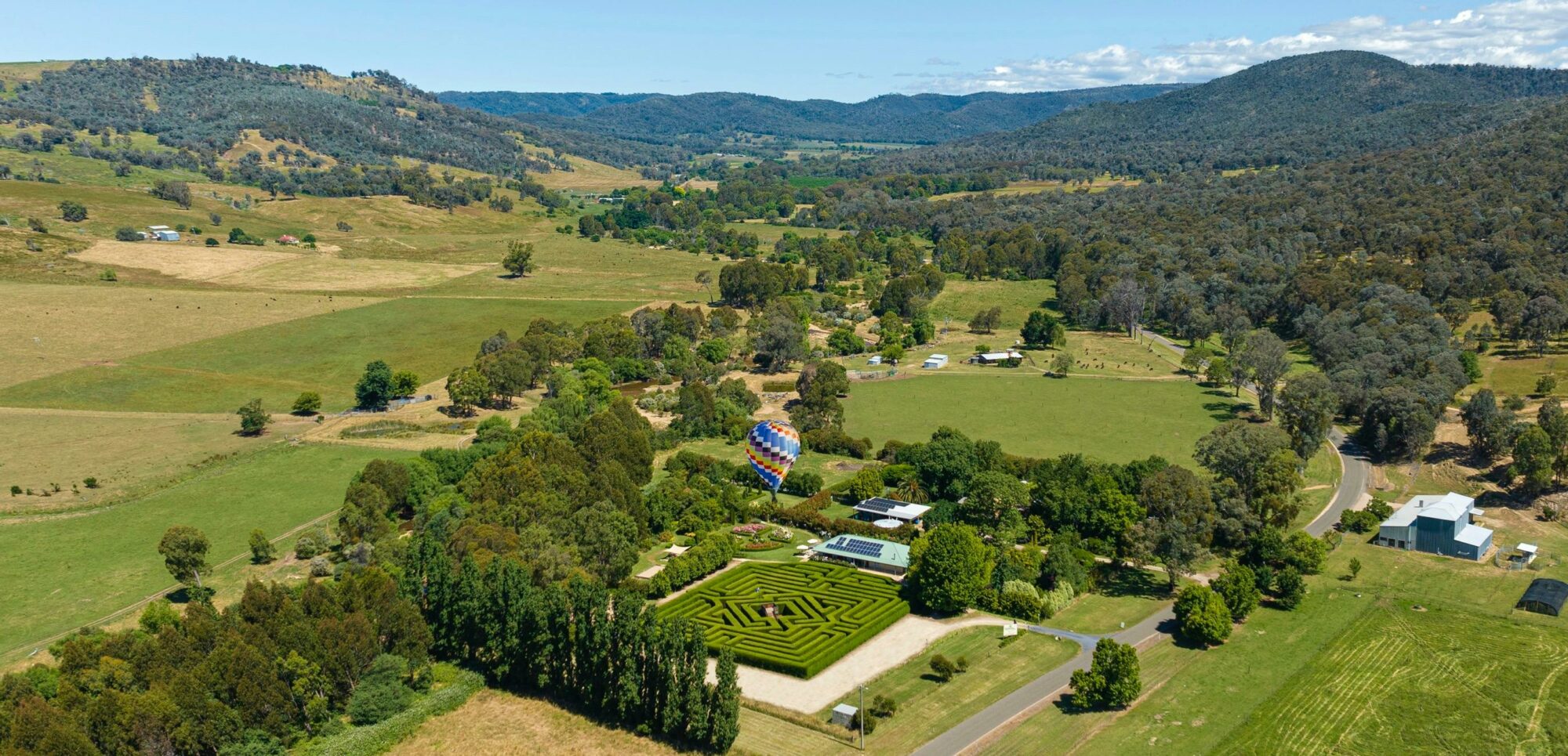 An aerial showing Brookfield Maze, a hot air balloon and the backdrop of the beautiful 15 mile creek