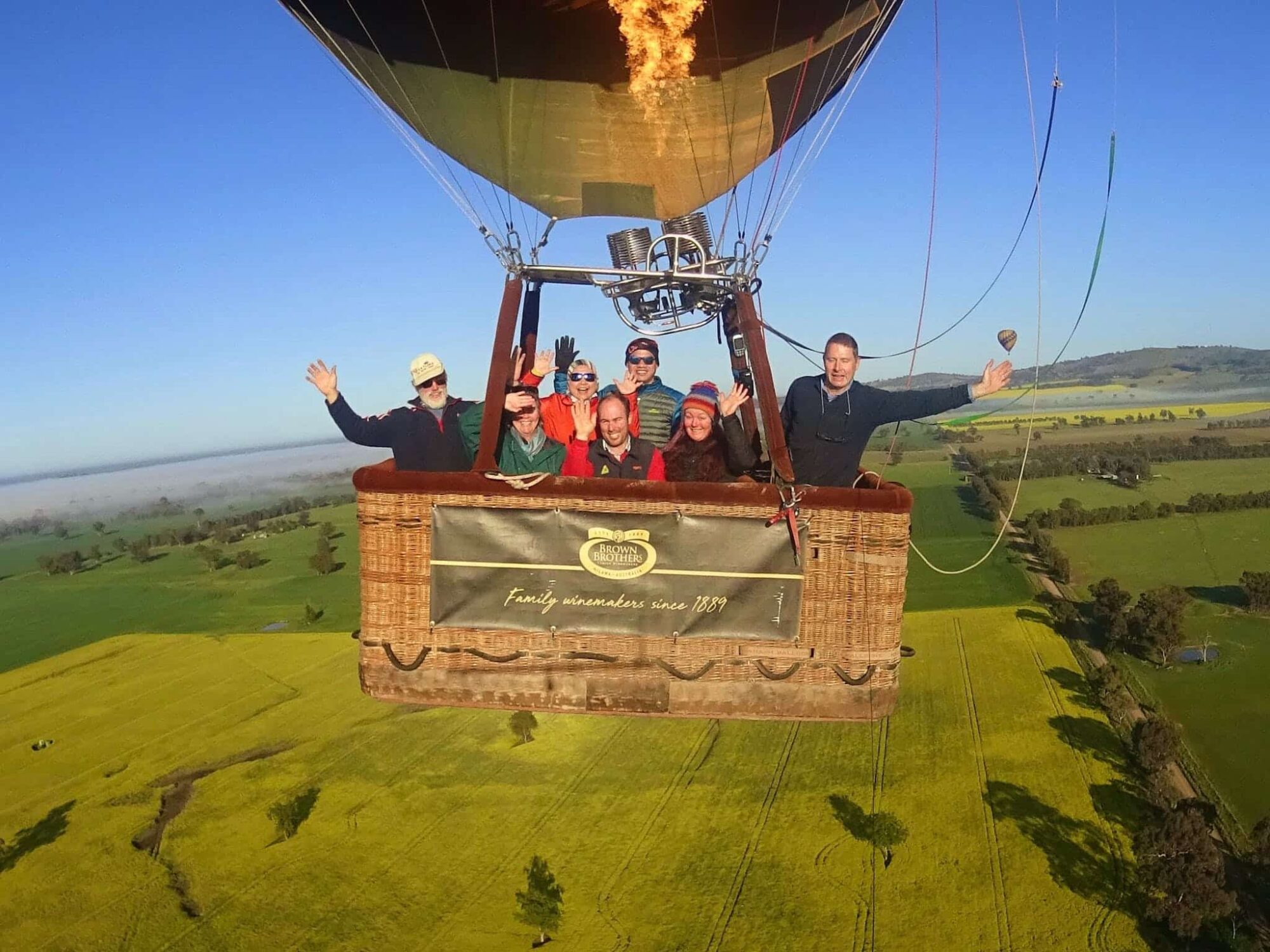 Balloon basket with guests aloft over the canola fields