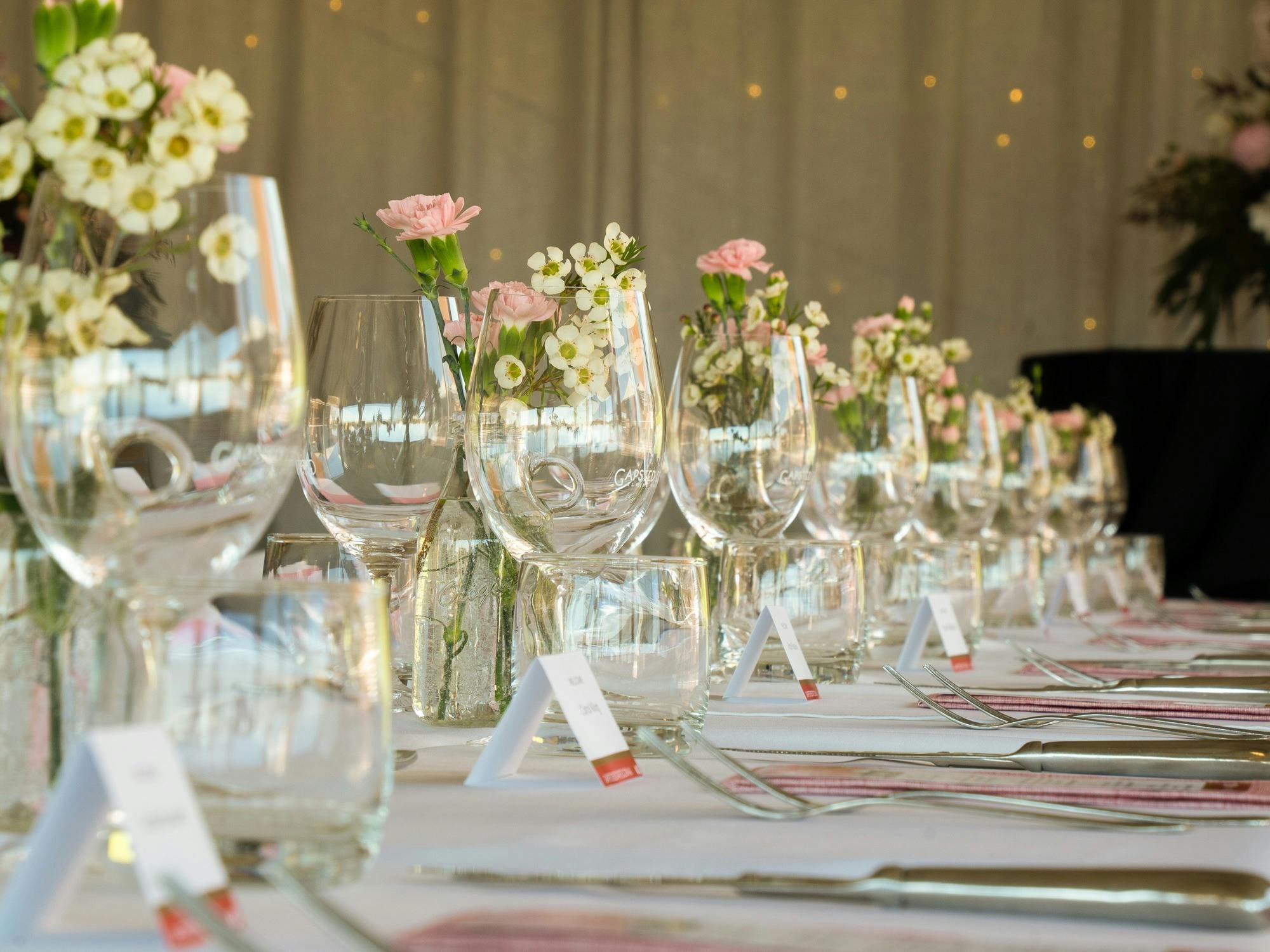 wine glasses and spring flowers on a long table