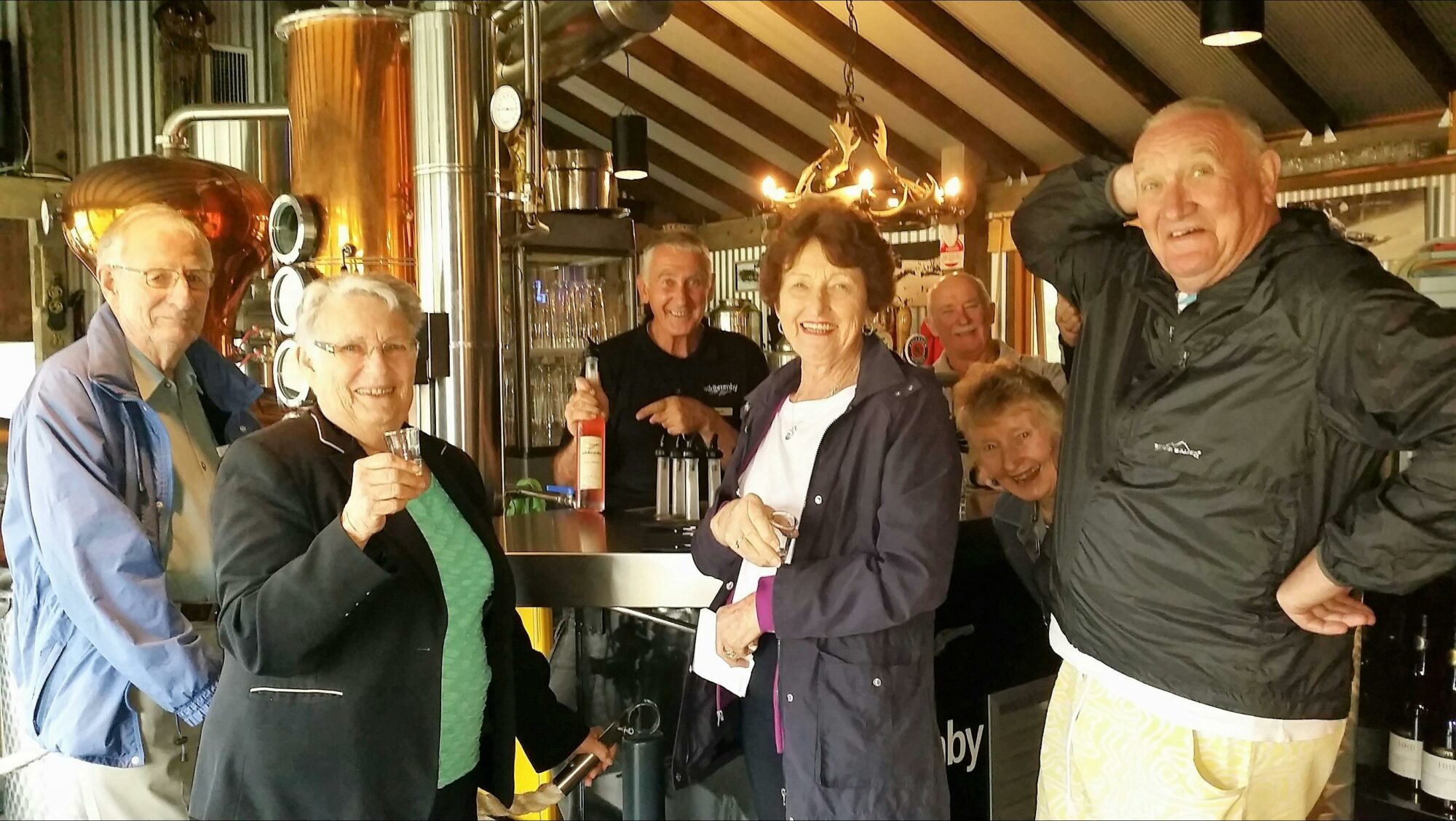 Six people in front of schnapps bar inside distillery