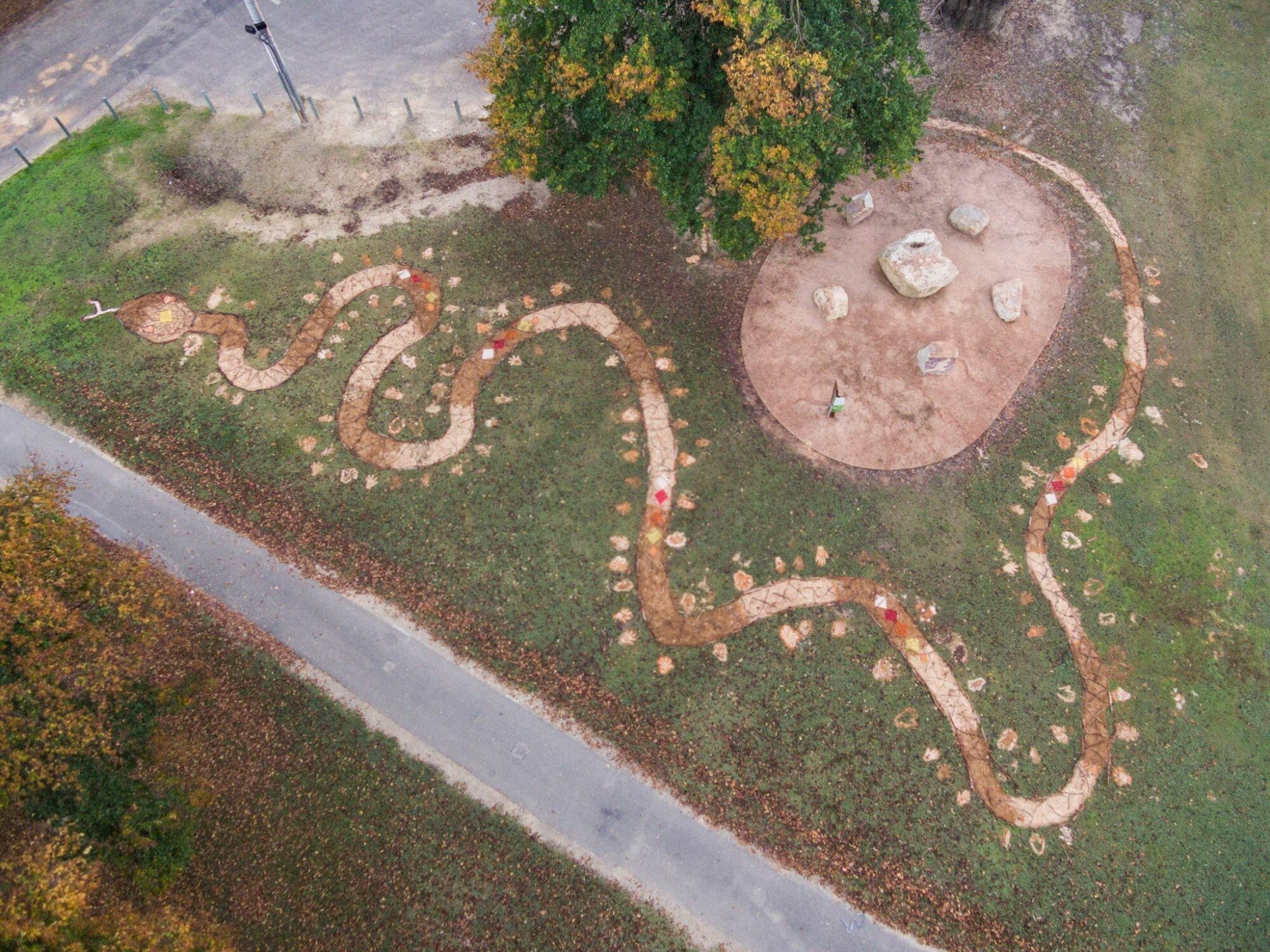 Aerial View of serpent artwork, hand prints, brown, tan, cream, with diamonds of red, white & yellow