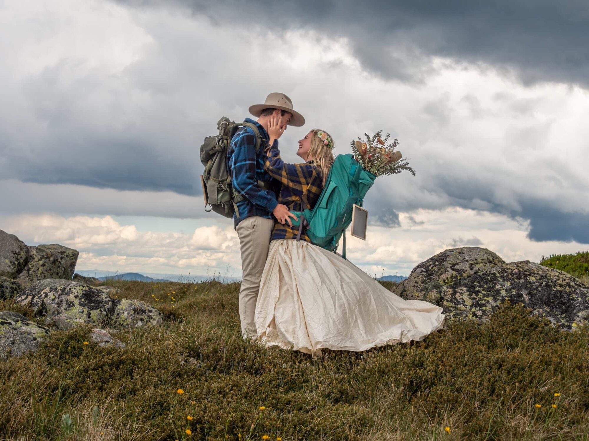 A couple just to be married are enjoying each others company as they hike over Mt Stirling.
