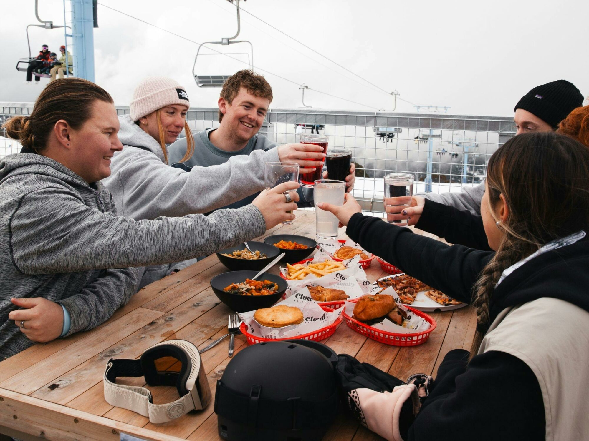 An image of a group of friends on the Cloud 9 balcony enjoying lunch and cheering their drinks