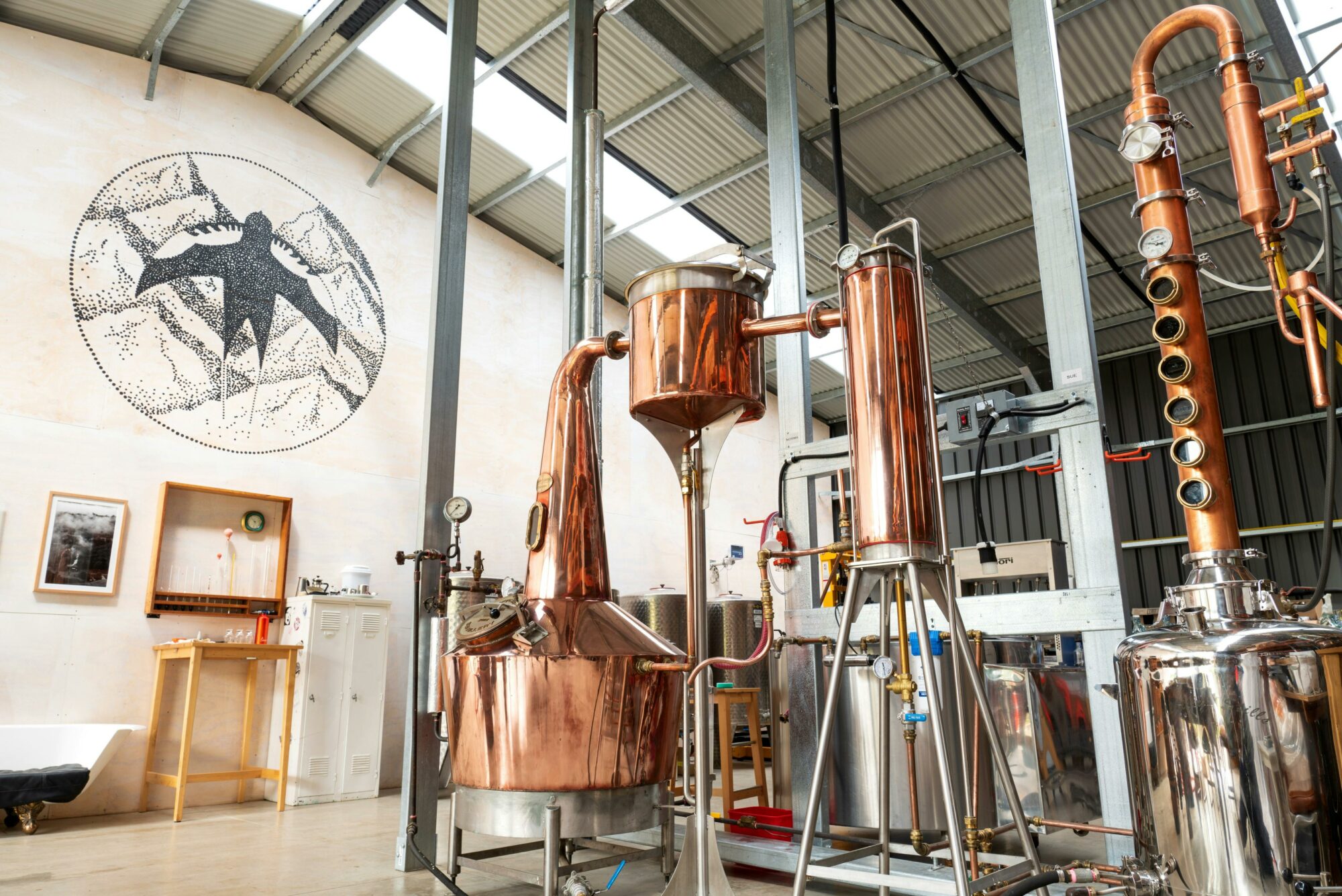 A view of the inside of Swiftcrest Distillery showing copper stills and pipework