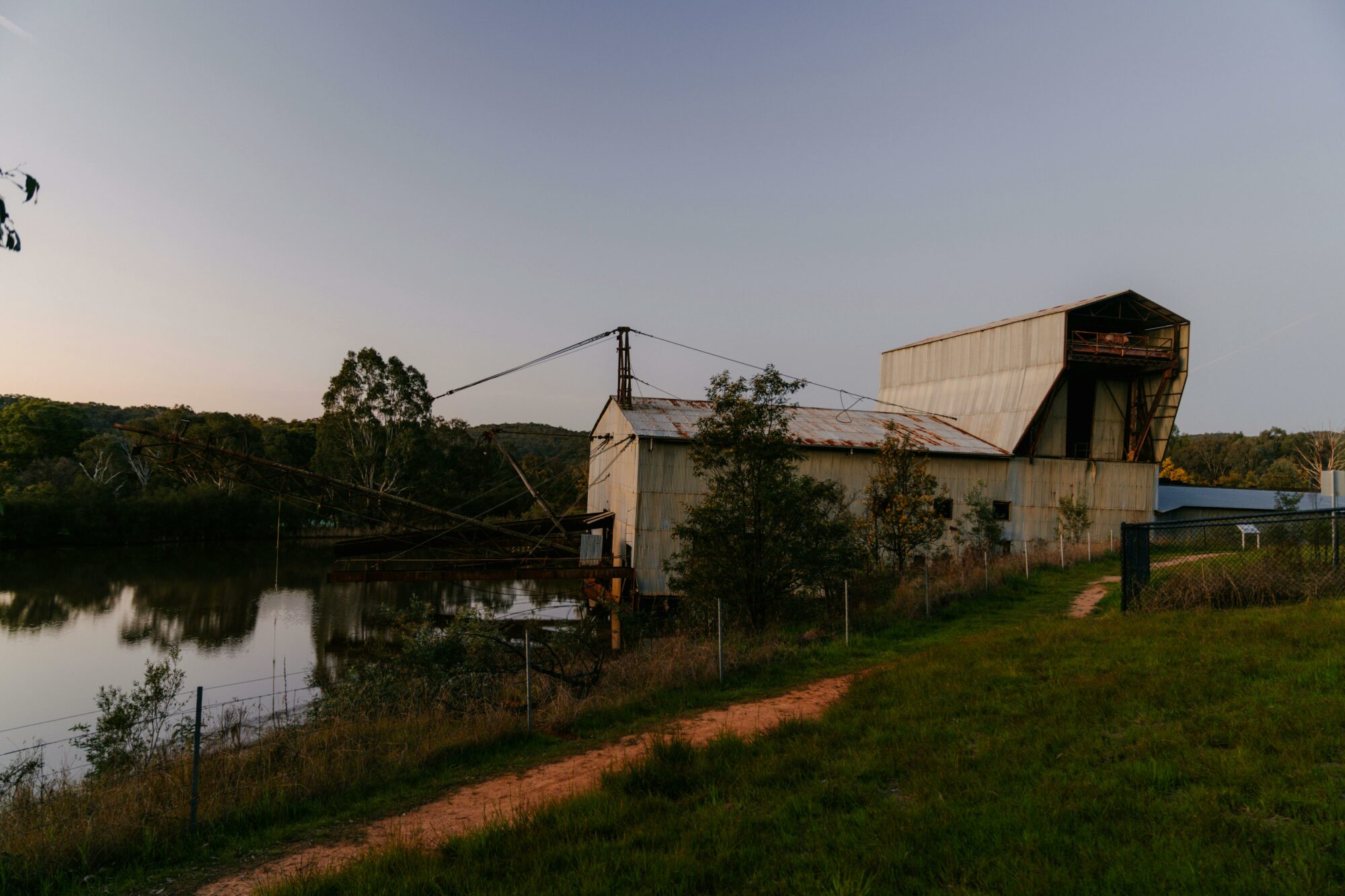 Large metal machinery on lake with footpath at forefront