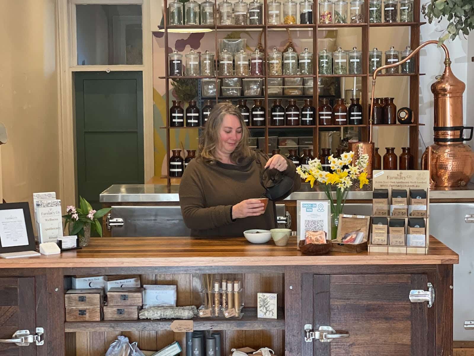 Lady standing behind a counter pouring tea