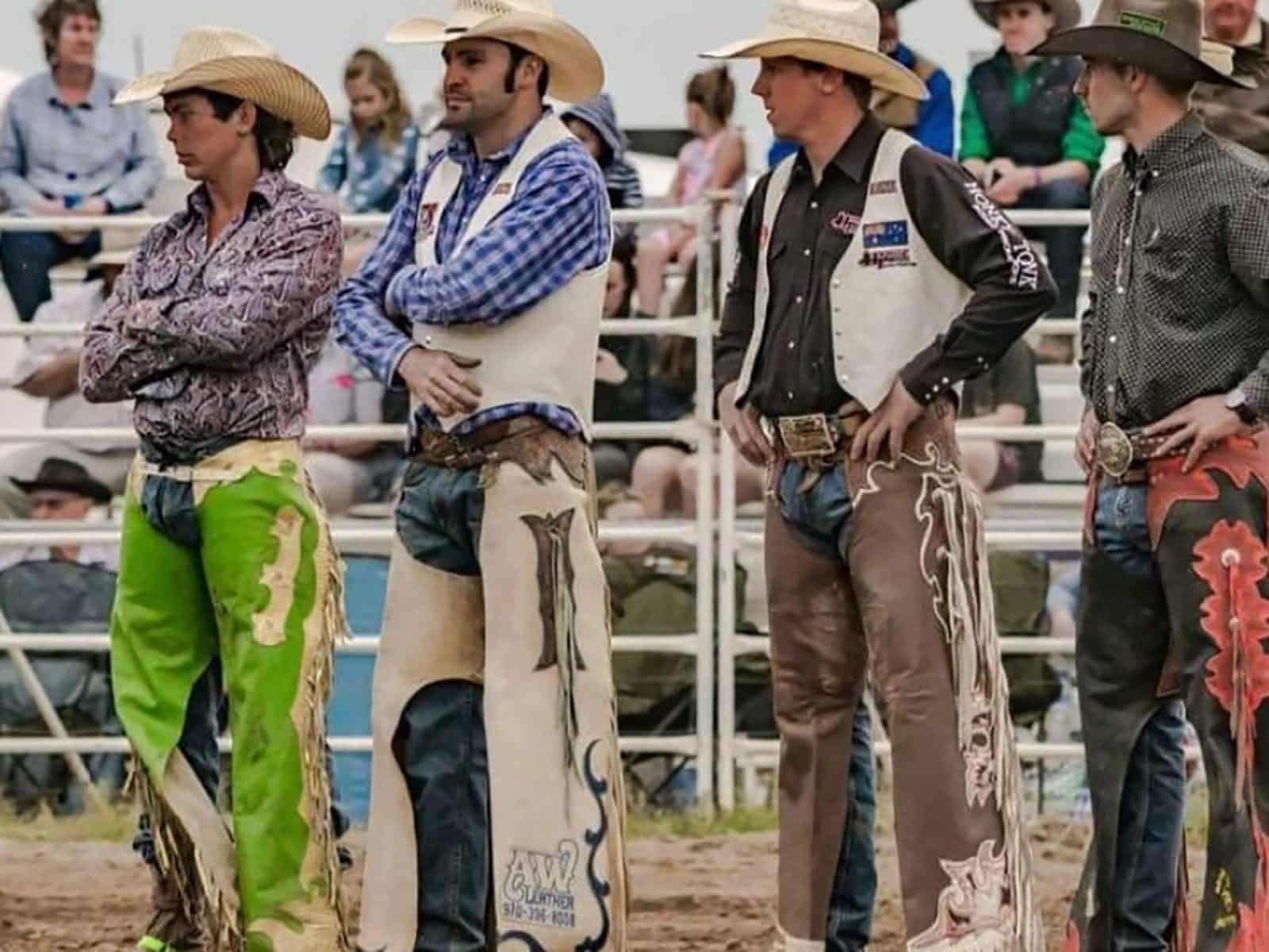 4 cowboys in stockyard watching a rodeo