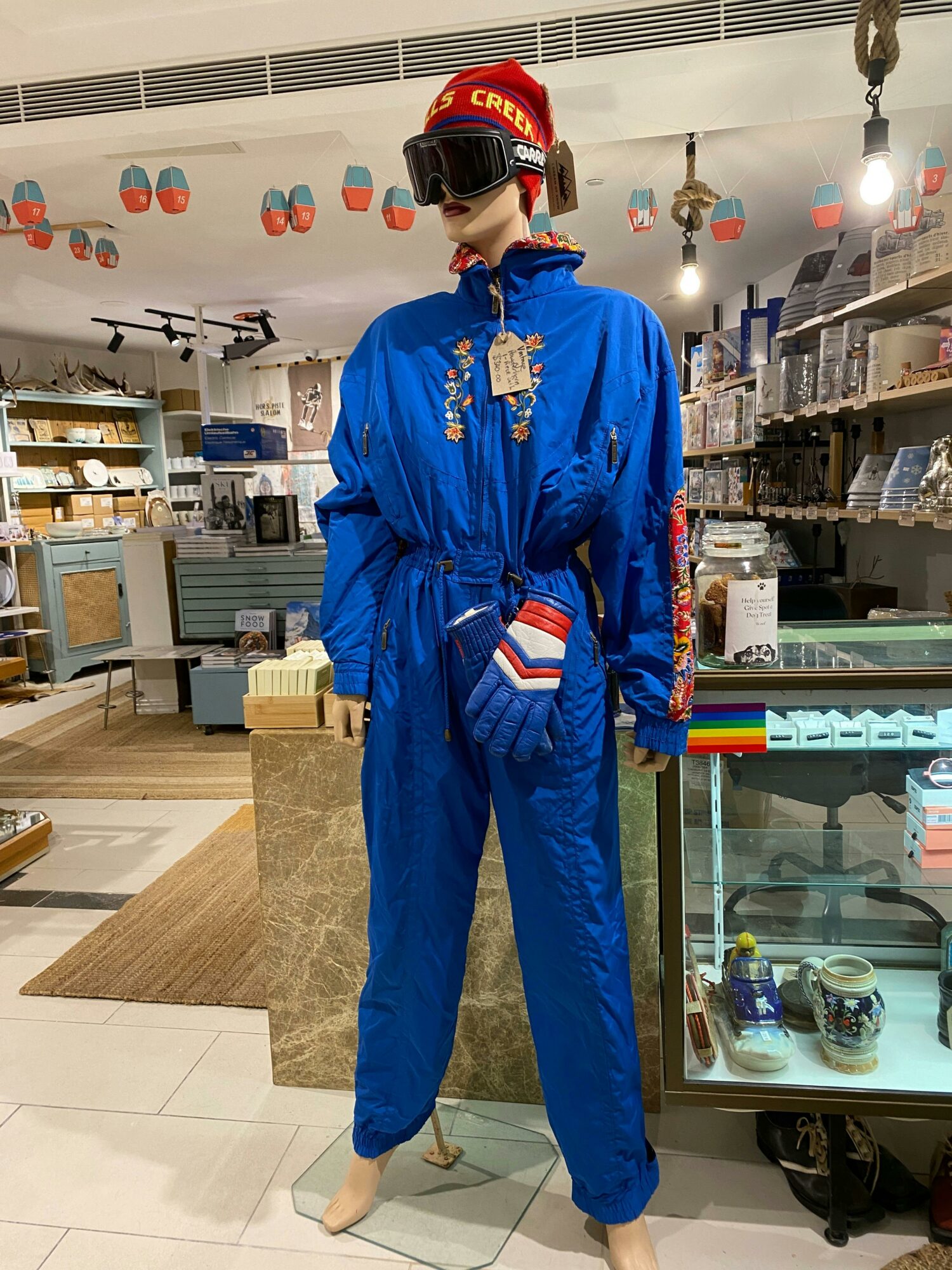 Photo of a blue vintage snow suit in front of a shop display cabinet