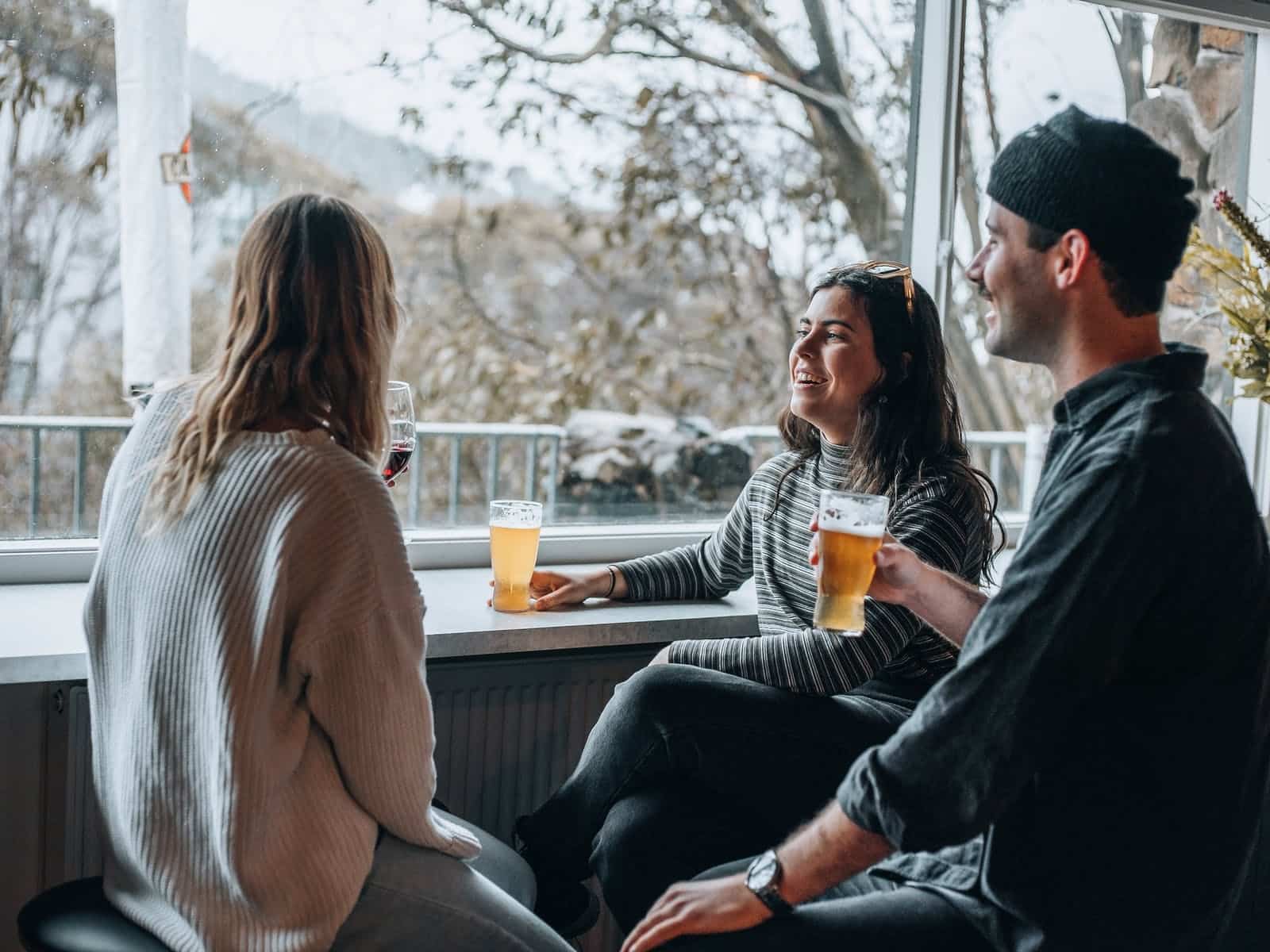Three people having a beer at the restaurant window