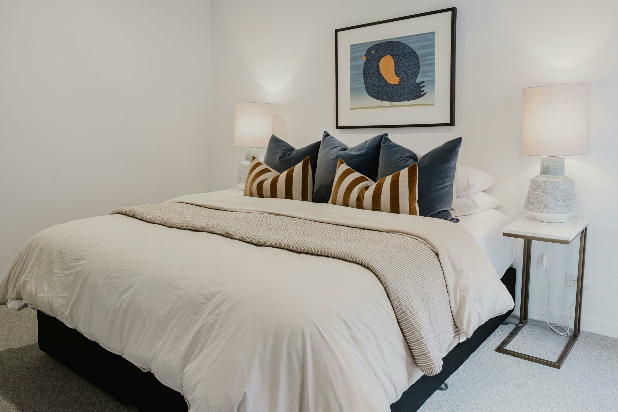 Hester arthouse townhouse bedroom with bed, table side lamp and painting hanging on the wall