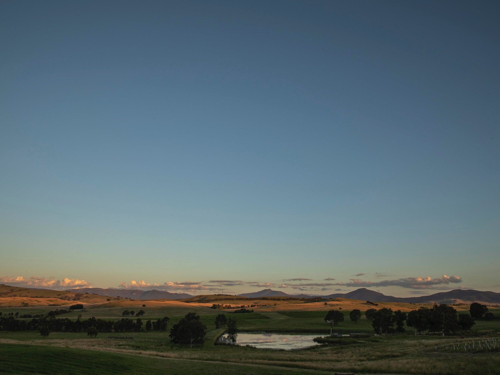 sunset view overlooking Mt Buller and Timbertop with a dam in the foreground
