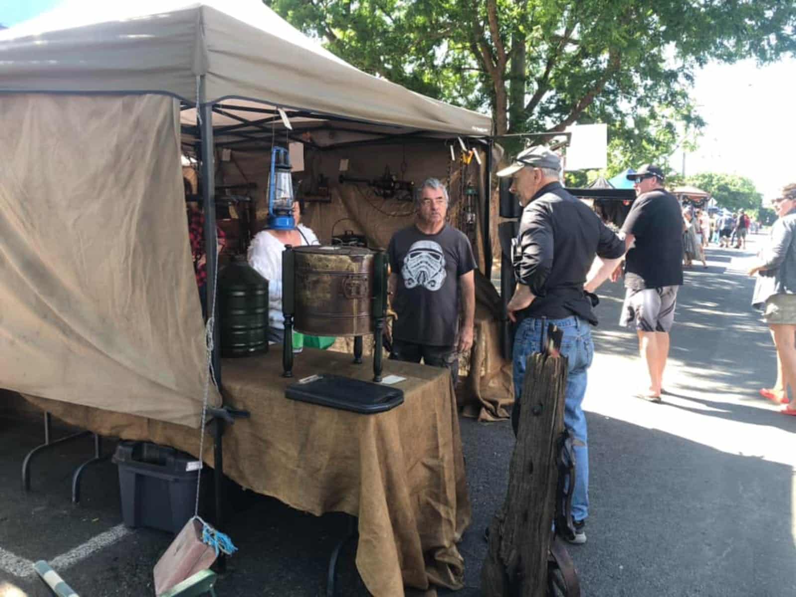 Two men standing outside a steampunk wares stall.
