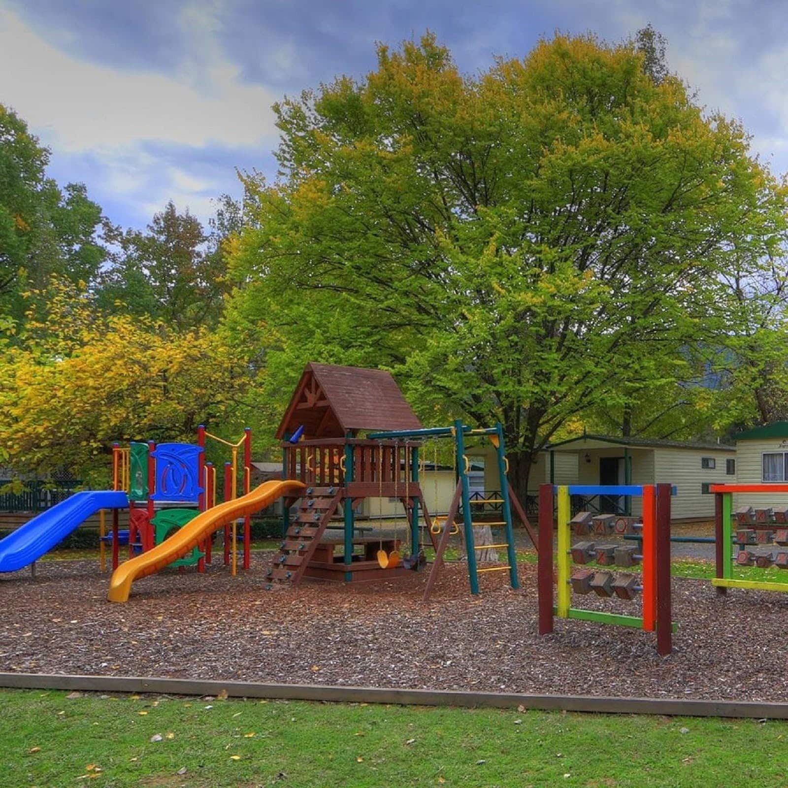 a playground surrounded by big green trees