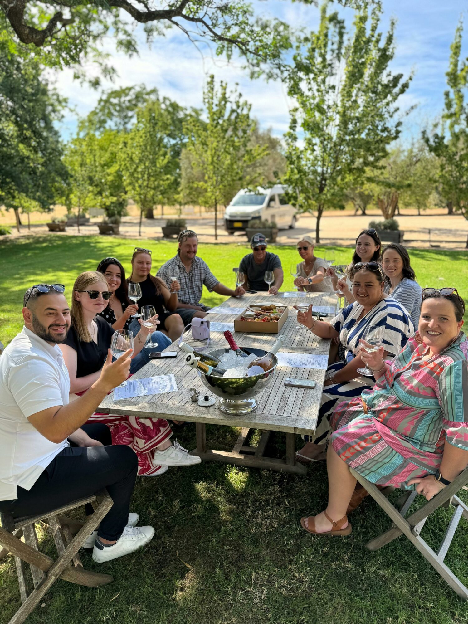 group of people sitting at table enjoying wine tasting