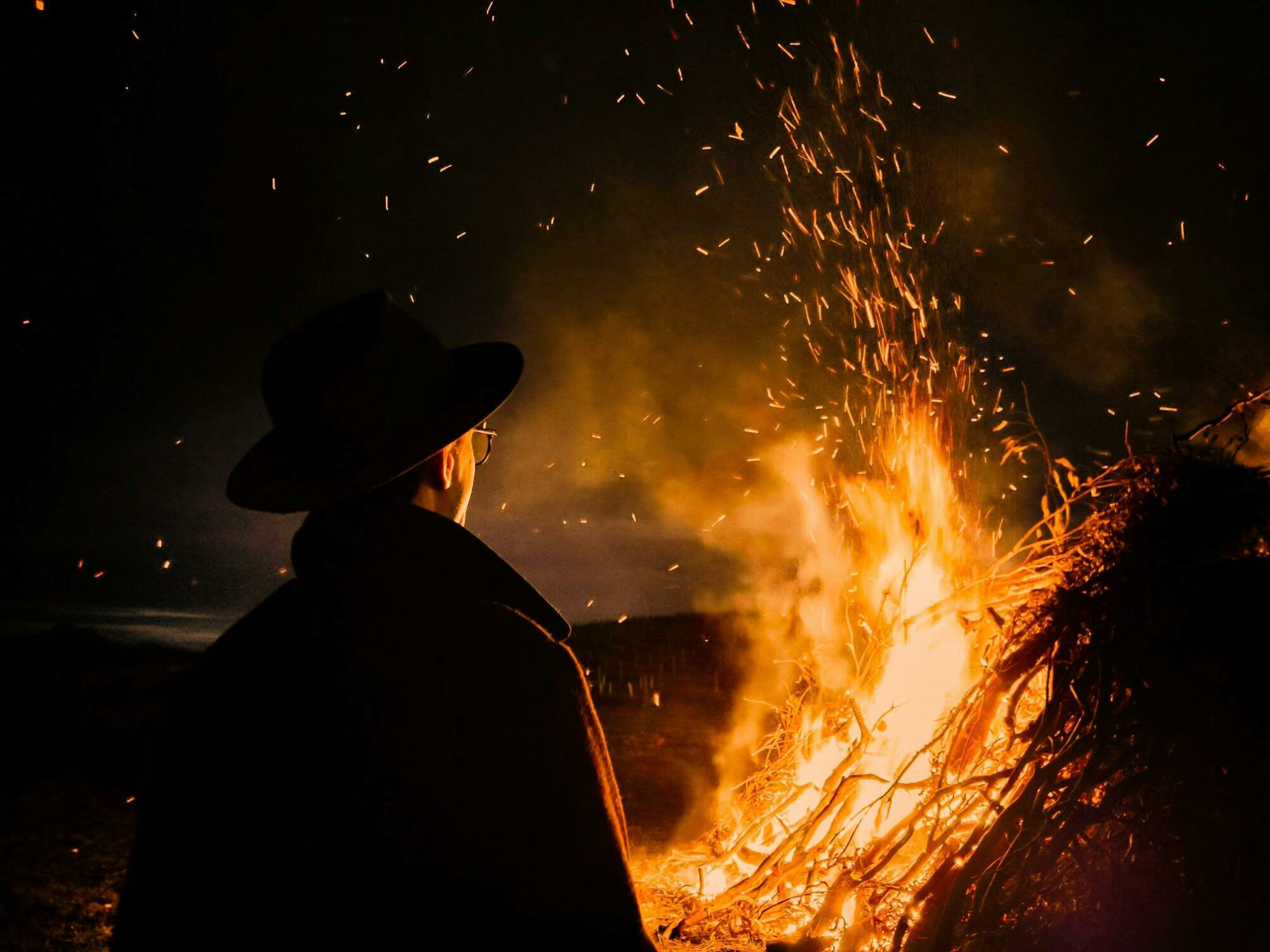 Man standing in front of a bonfire