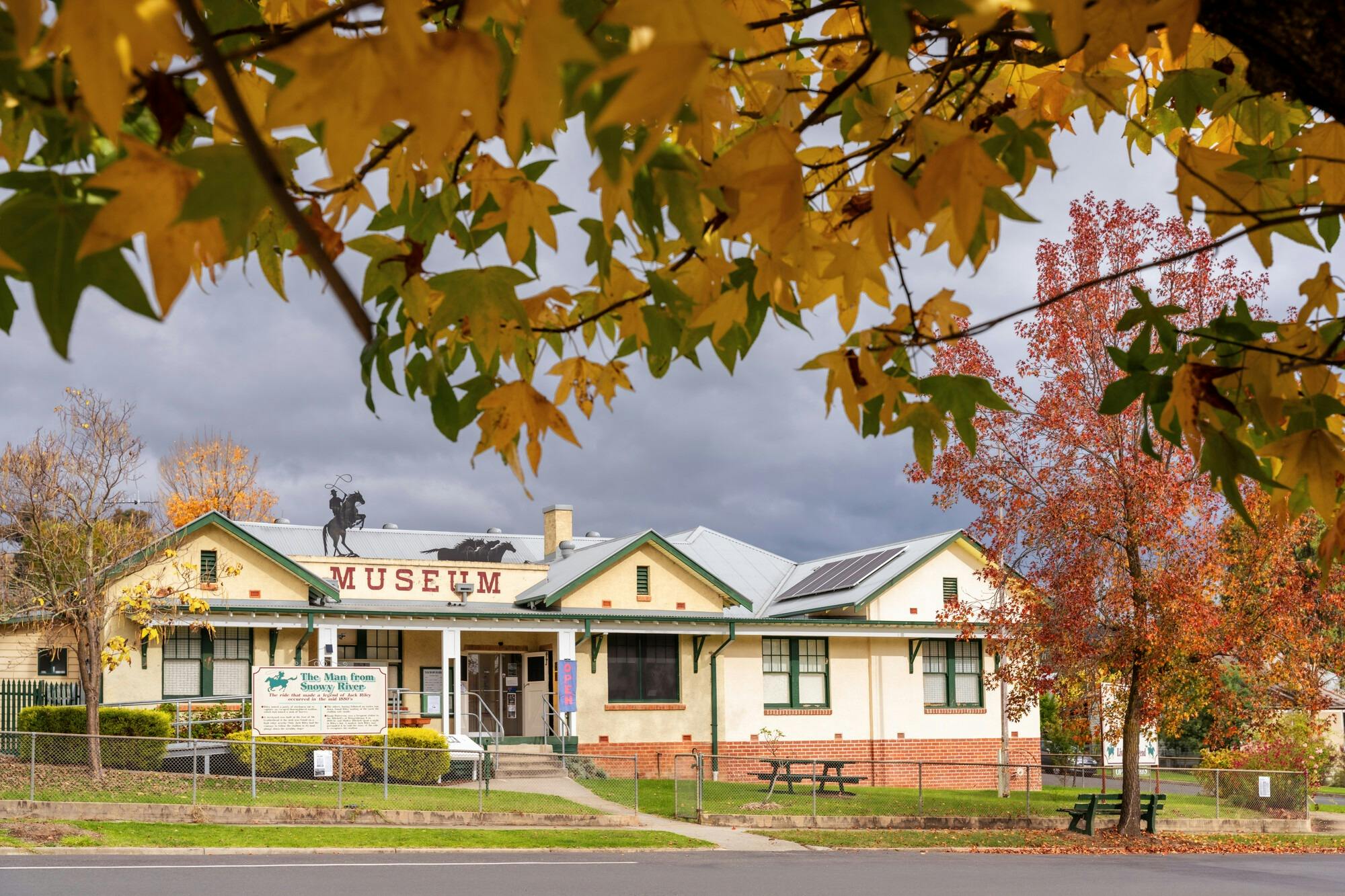 The Man From Snowy River Museum framed by autumn foliage