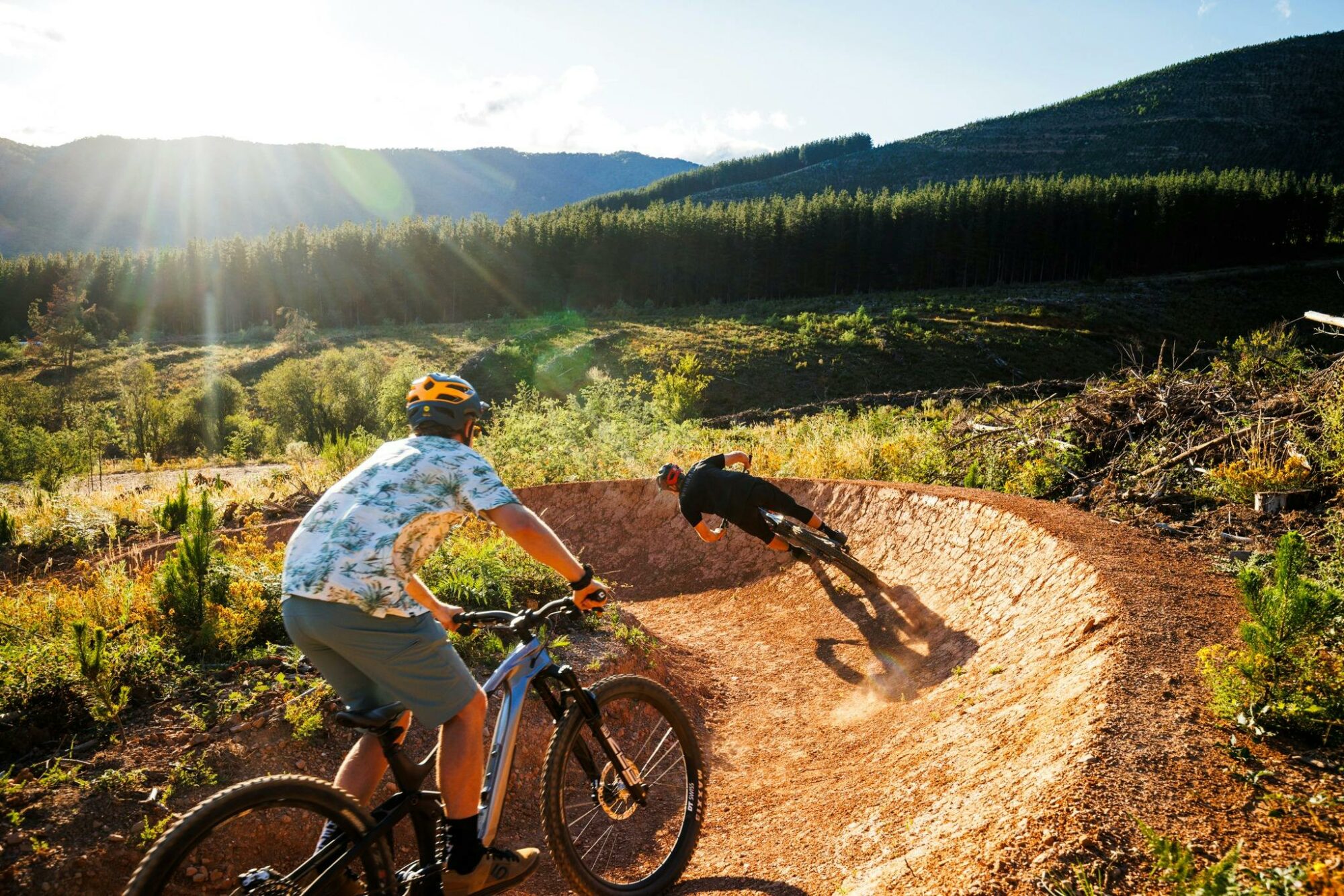 Two riders in morning with mountain backdrops