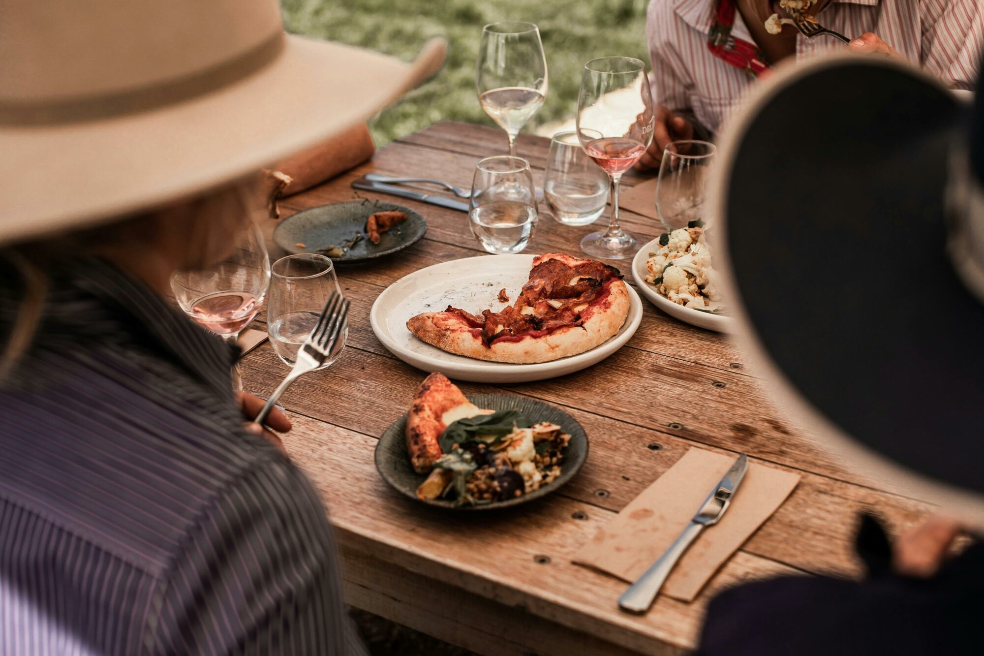 a pizza on a table, shot between two people