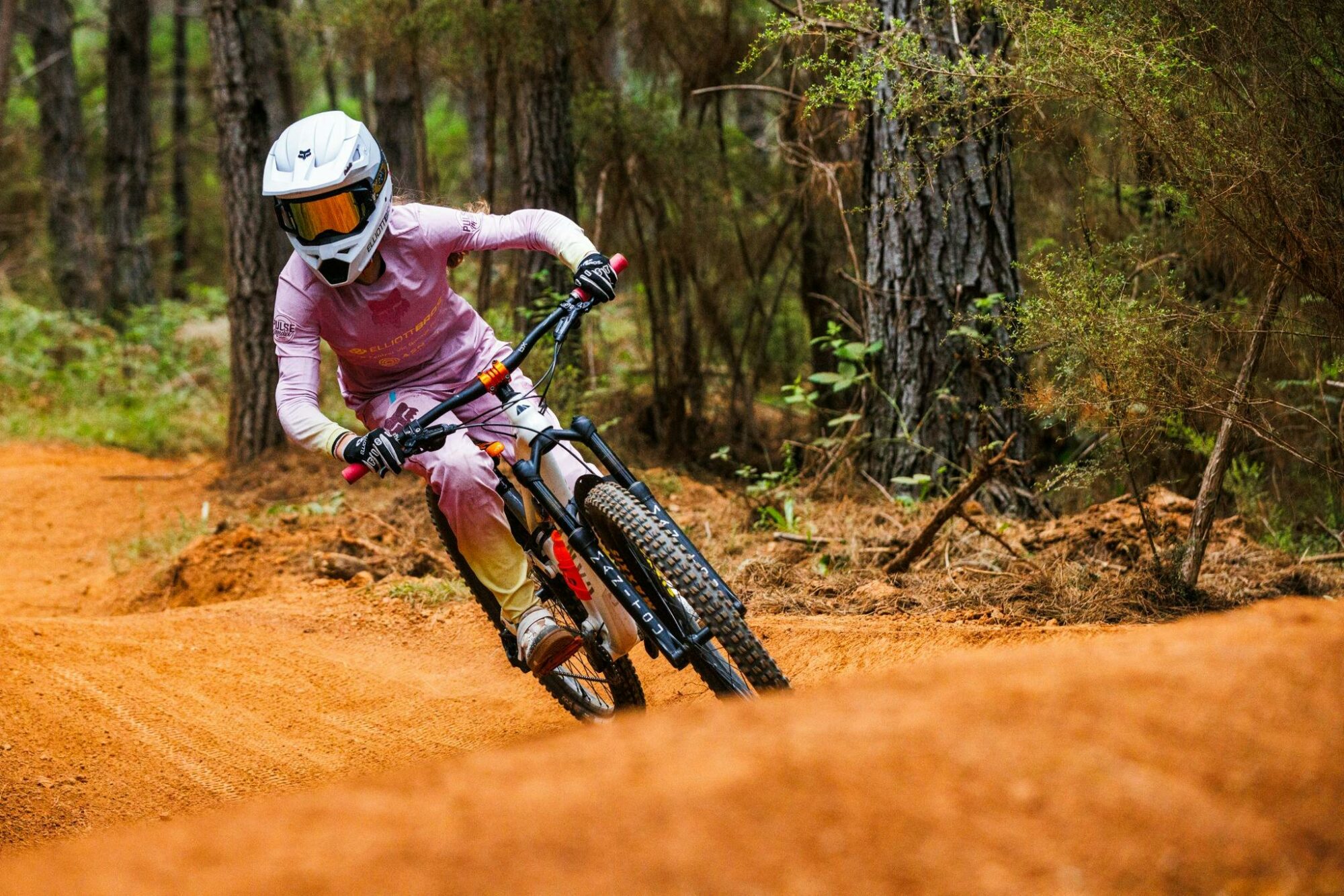 Young girl mountain biker riding at mystic bike park in bright