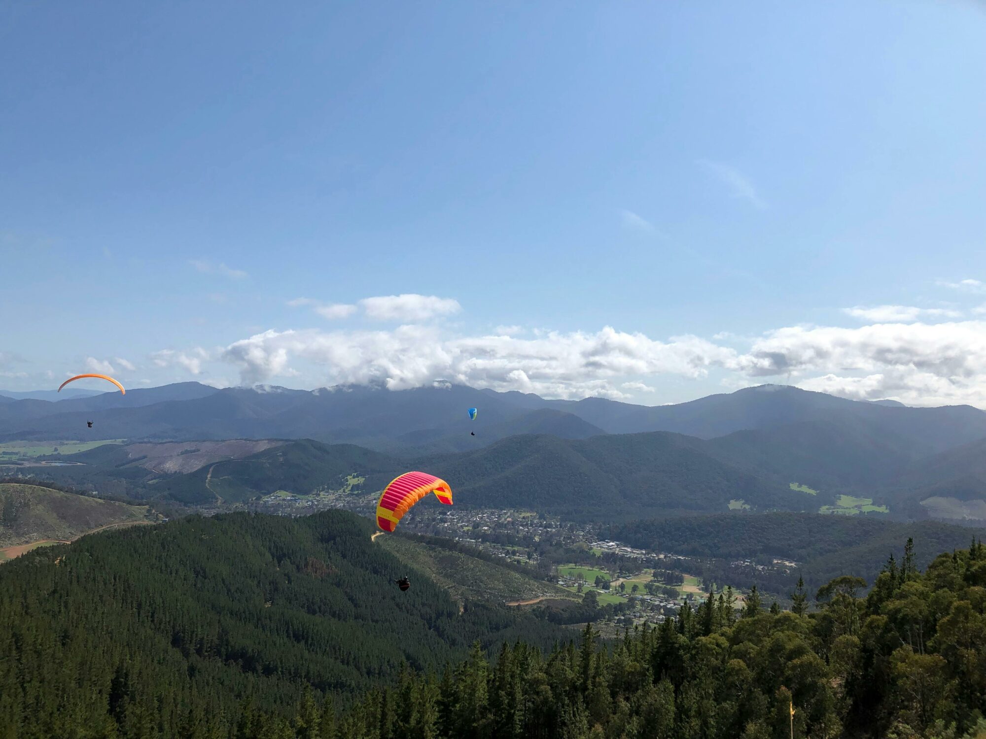 Multiple gliders are above Bright and it's mountains