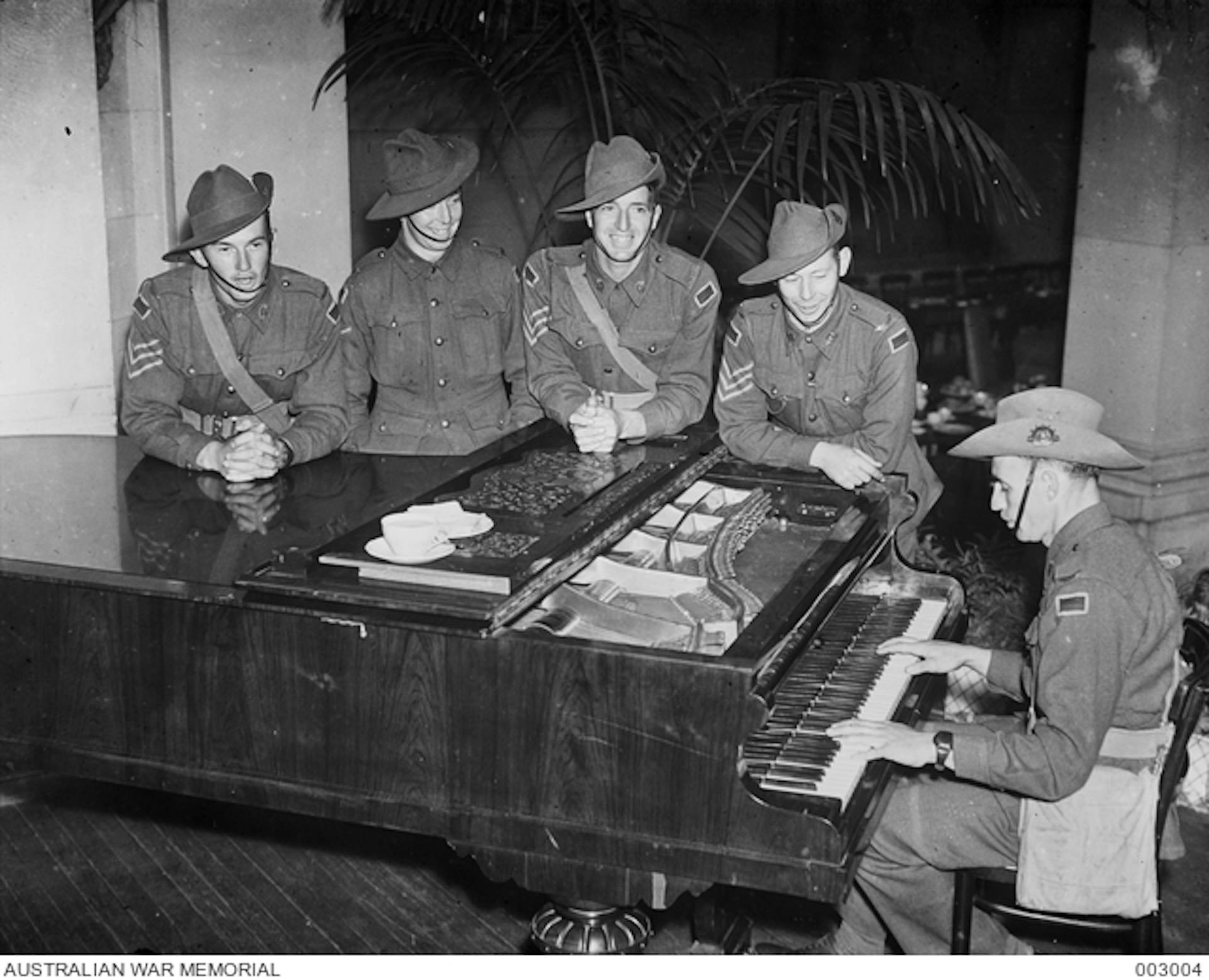 soldiers standing around a piano