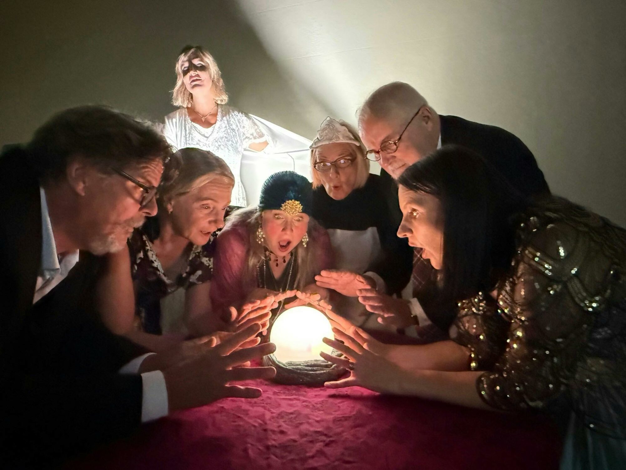 A group of people gather over a light