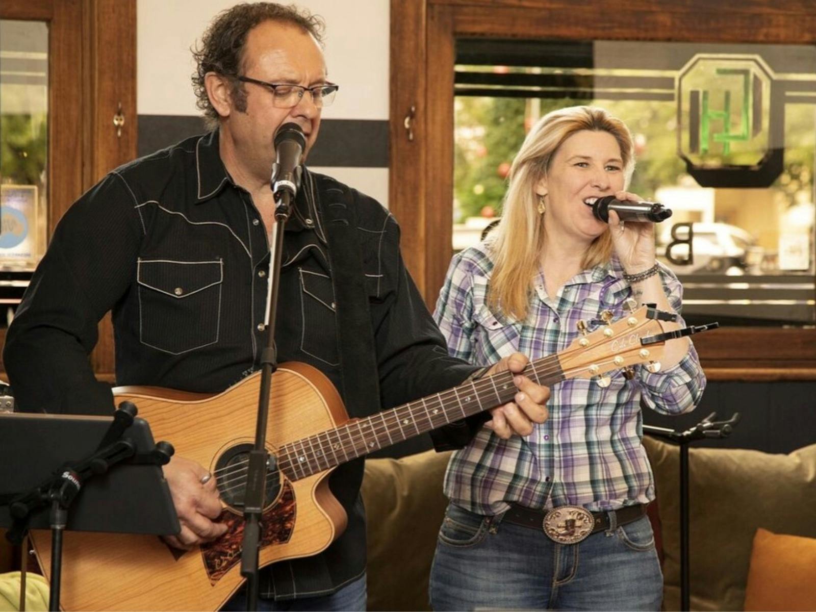 man and woman singing and playing a guitar