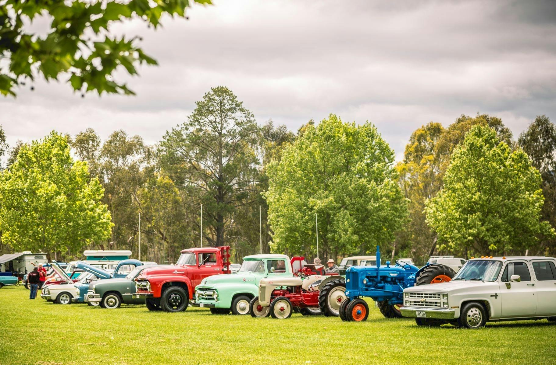 A sweeping view of all vehicles lines up on the grass green oval