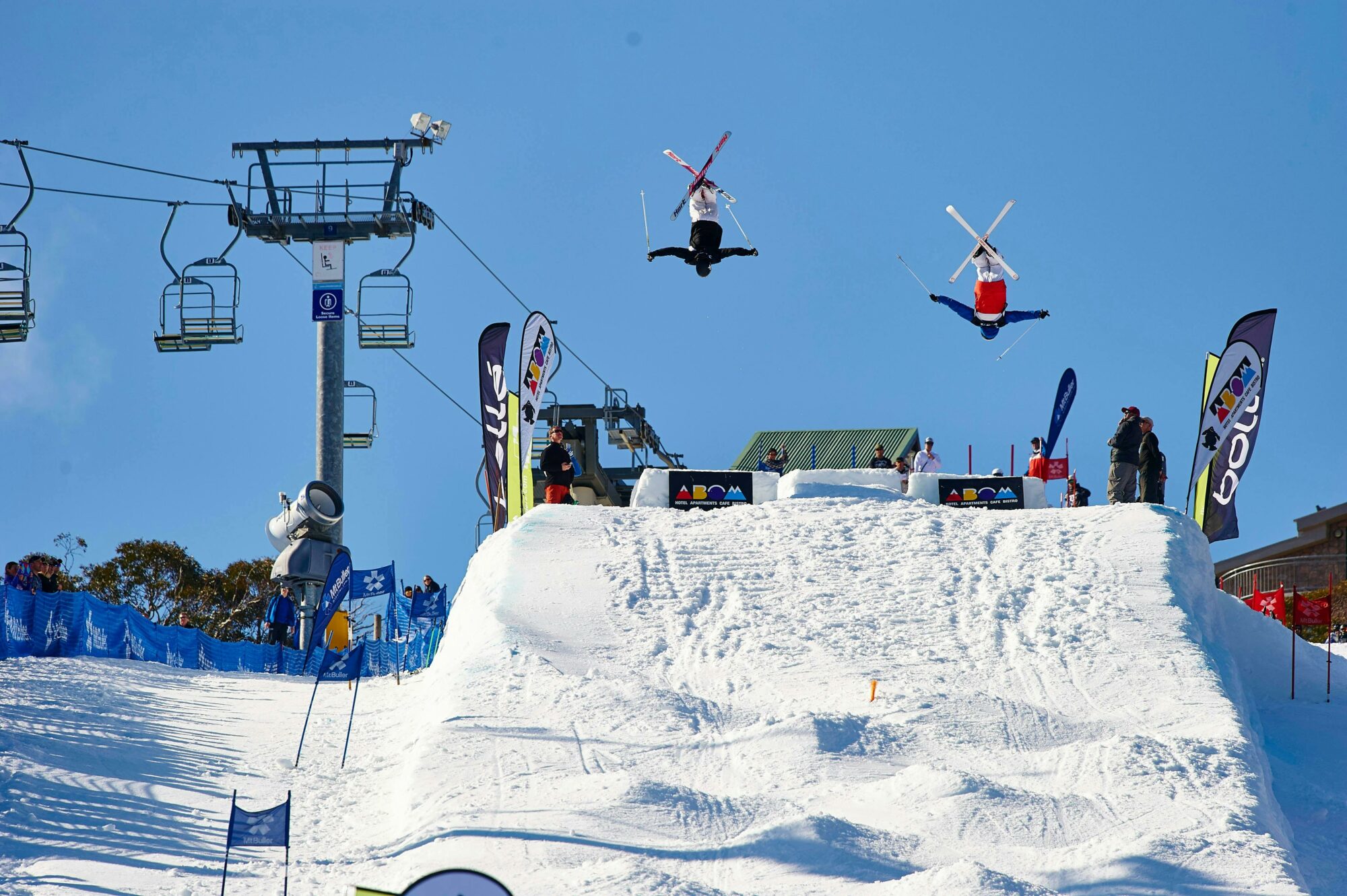 skiiers jumping over snow slopes