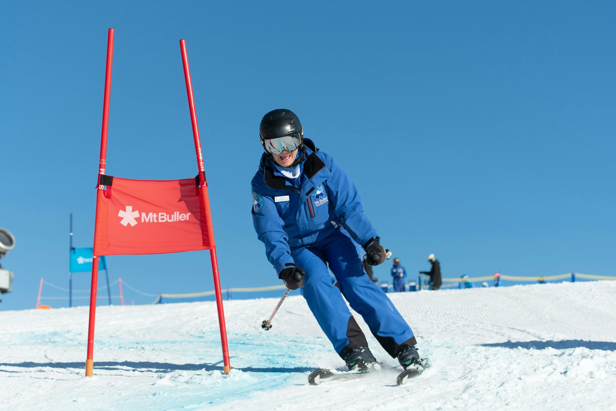Skiier on snow next to a flag that reads Mt Buller