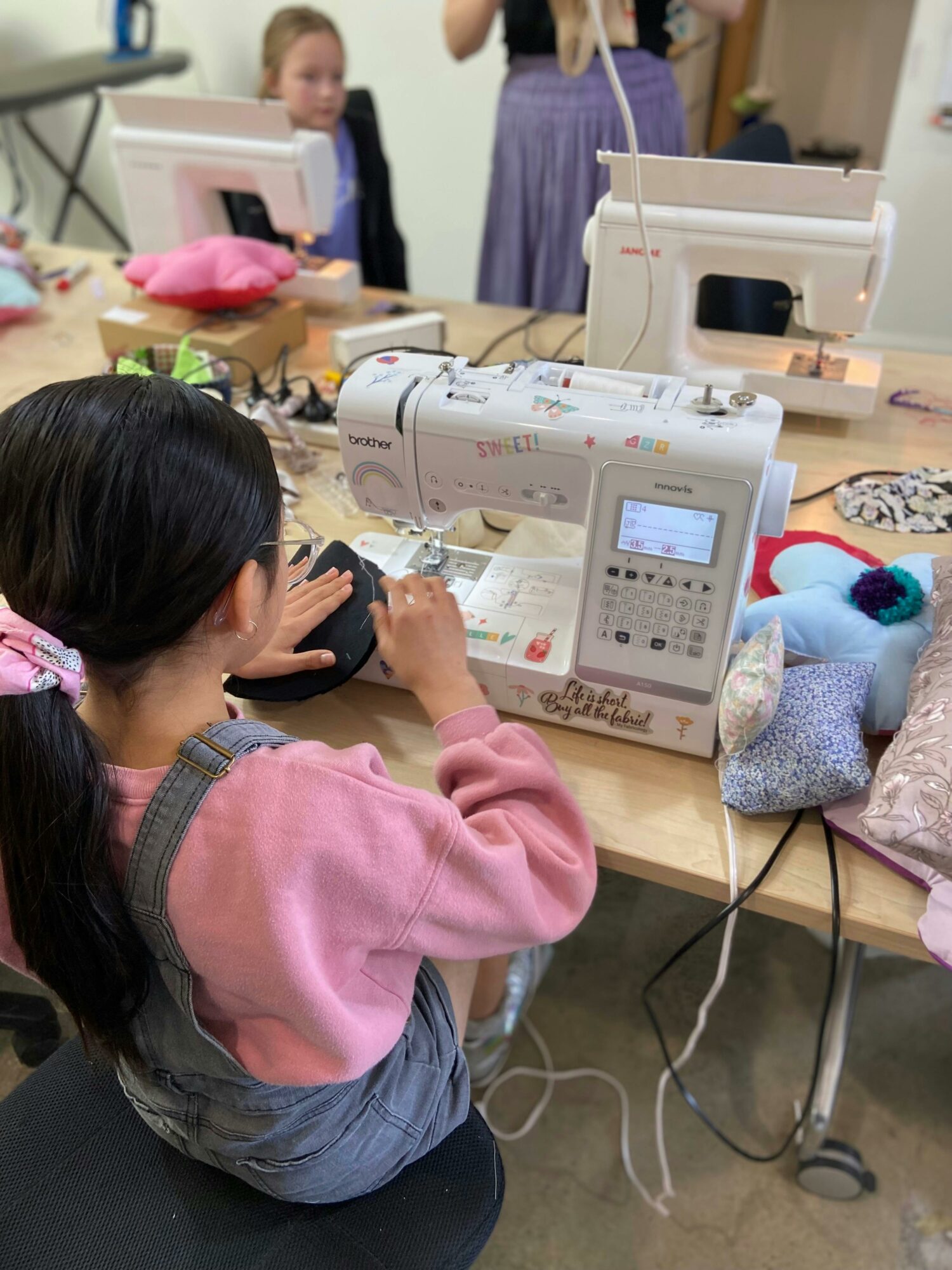 A young girl sewing on a sewing machine
