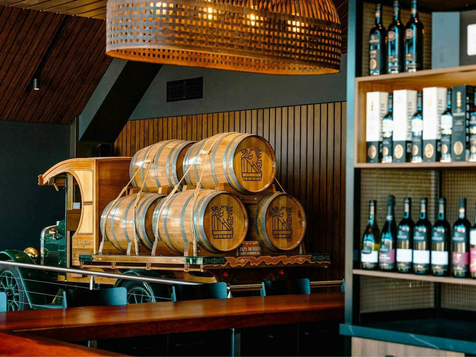 wooden barrels in  a bar with bottles on a shelf