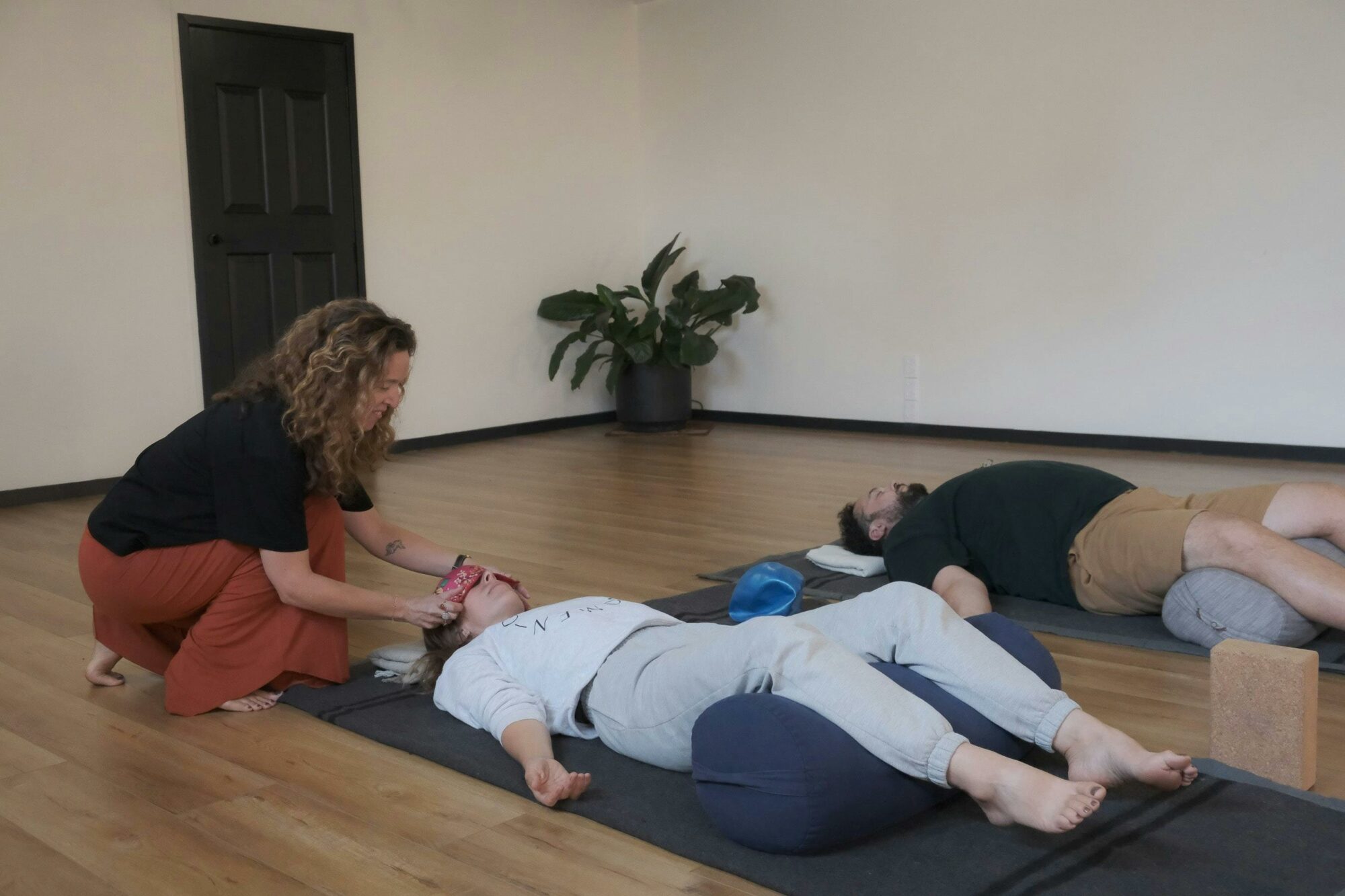 A person lying on the floor in a relaxing yoga pose