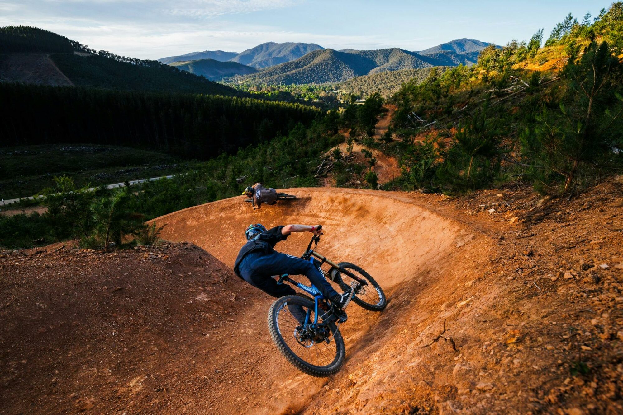 2 Riders on a trail with Bright township and mountains in the background