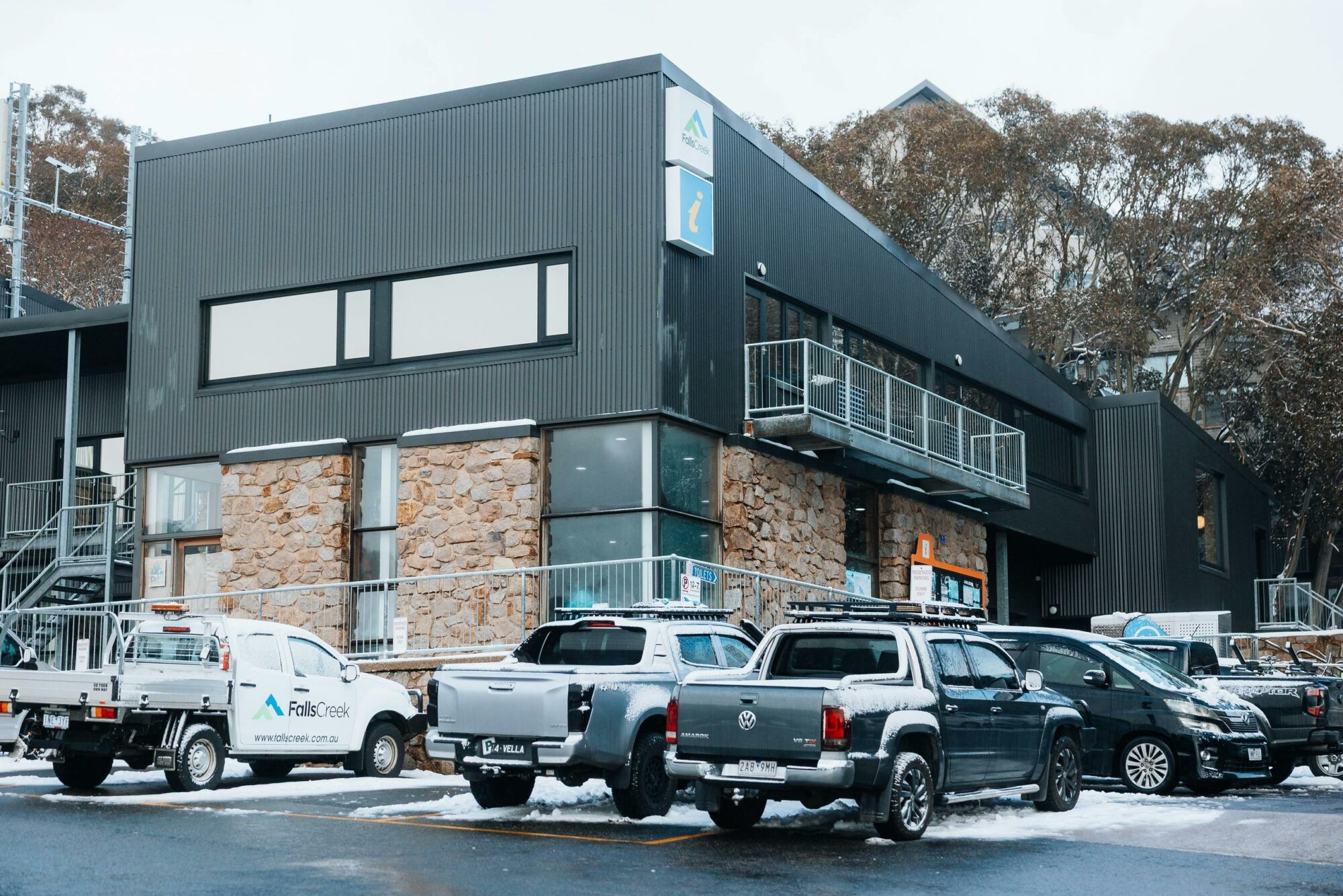 Two story building with cars parked in available  parking around the perimeter of the building.