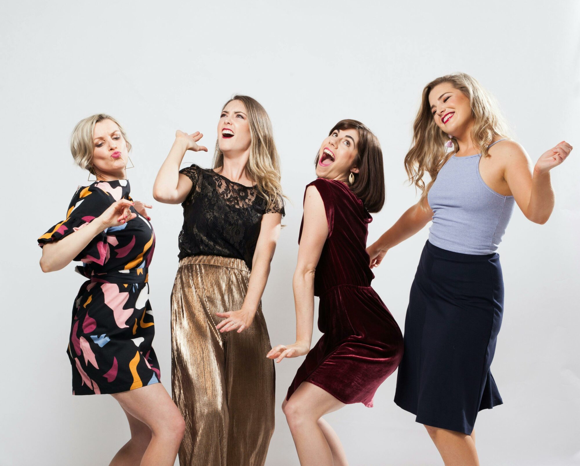 Two females one blonde on brunette in comedic dance pose