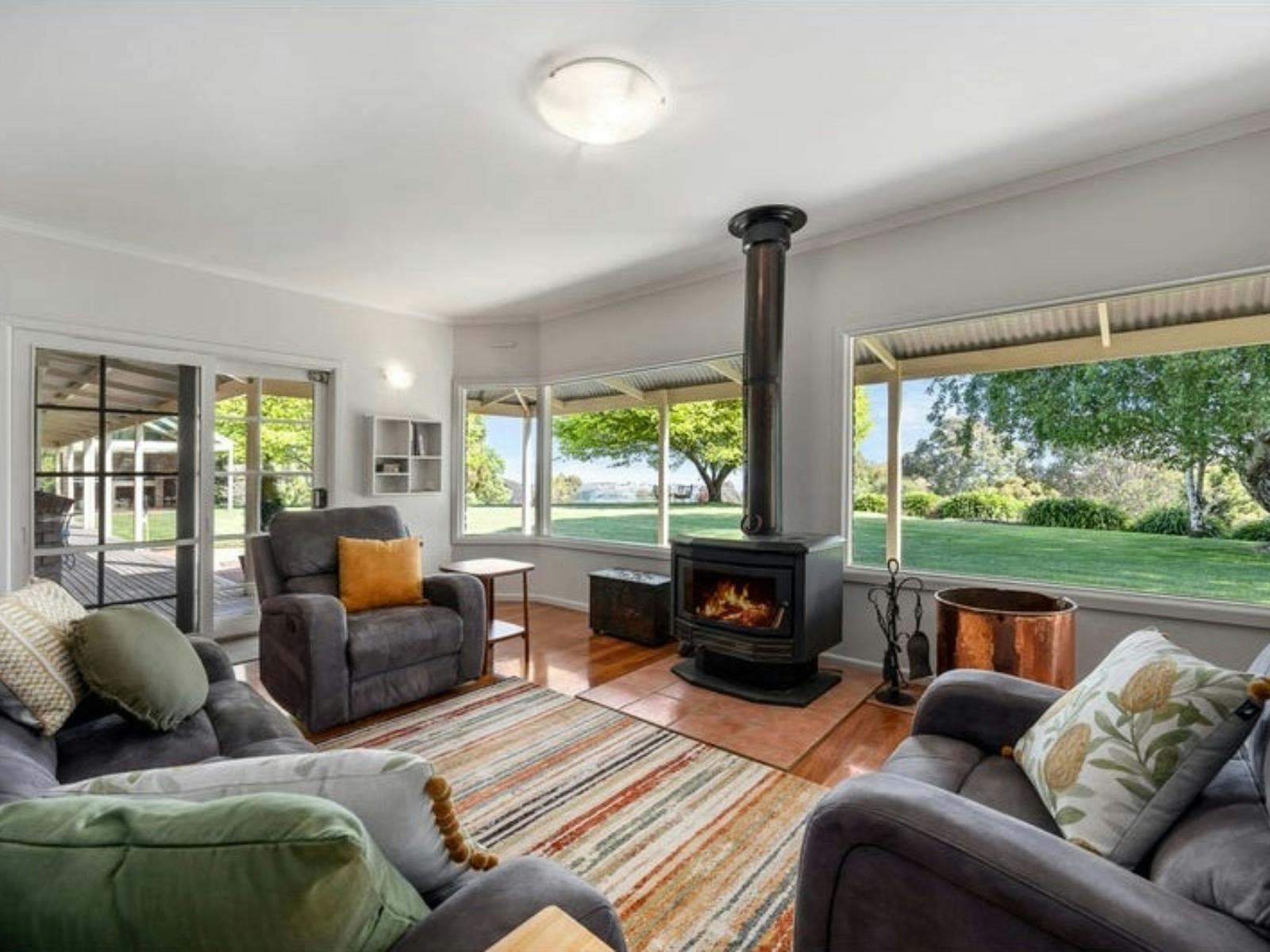 Living room with large windows at Sambar Ridge farm stay in Alexandra, Victoria.